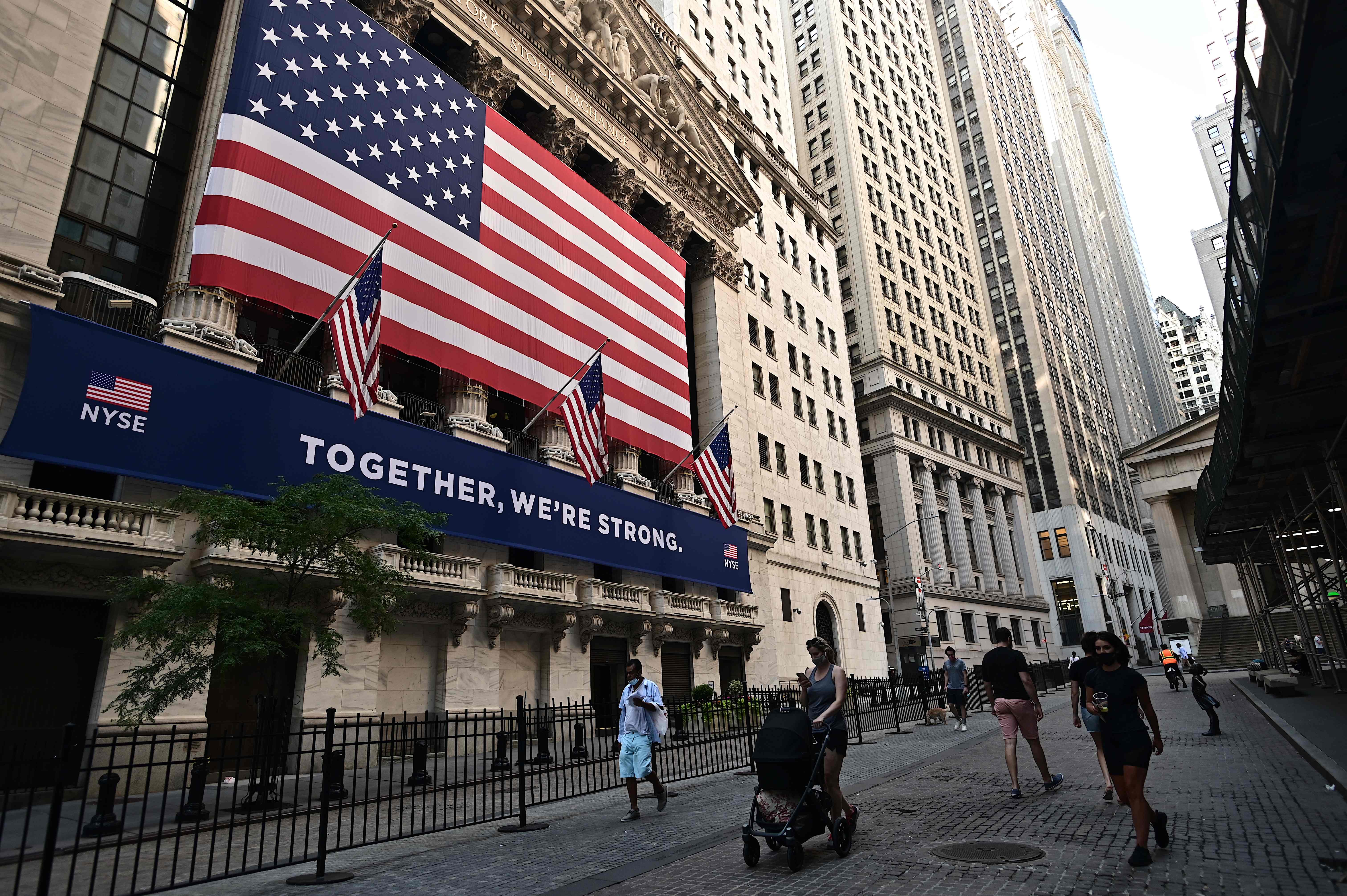 Sejumlah warga melintas di depan gedung Bursa Efek New York, Wall Street, AS. Pembukaan saham Wall Street menguat tipis.