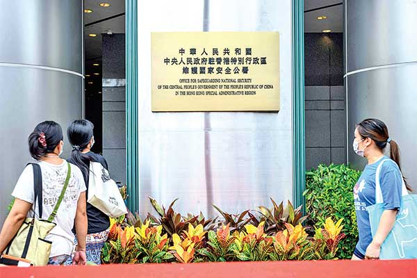 Pejalan kaki melintas di depan Kantor Keamanan Nasional Tiongkok yang resmi dibuka untuk pertama kalinya di Hong Kong