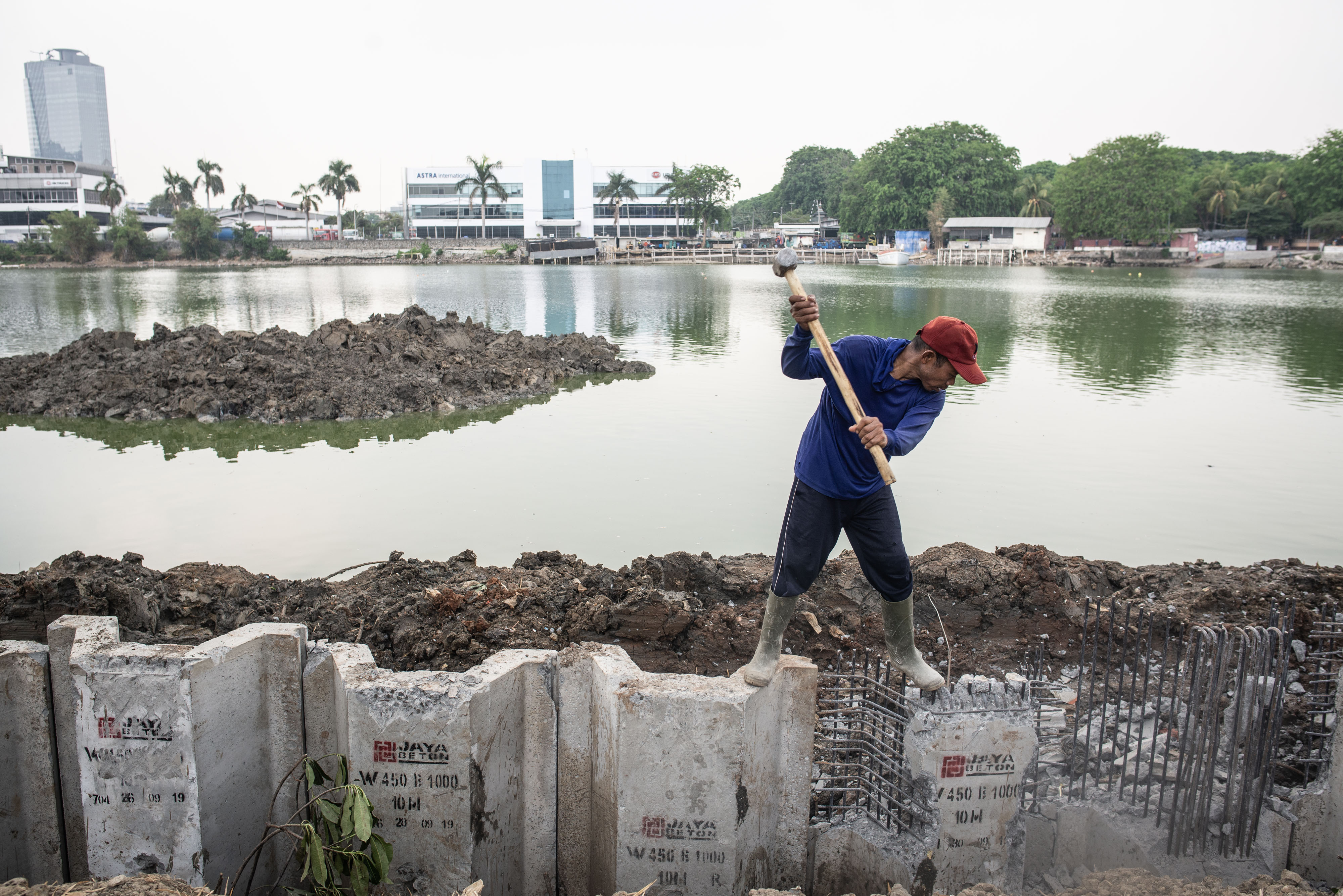 Pekerja menyelesaikan pemasangan turap di Waduk Sunter Selatan, Jakarta
