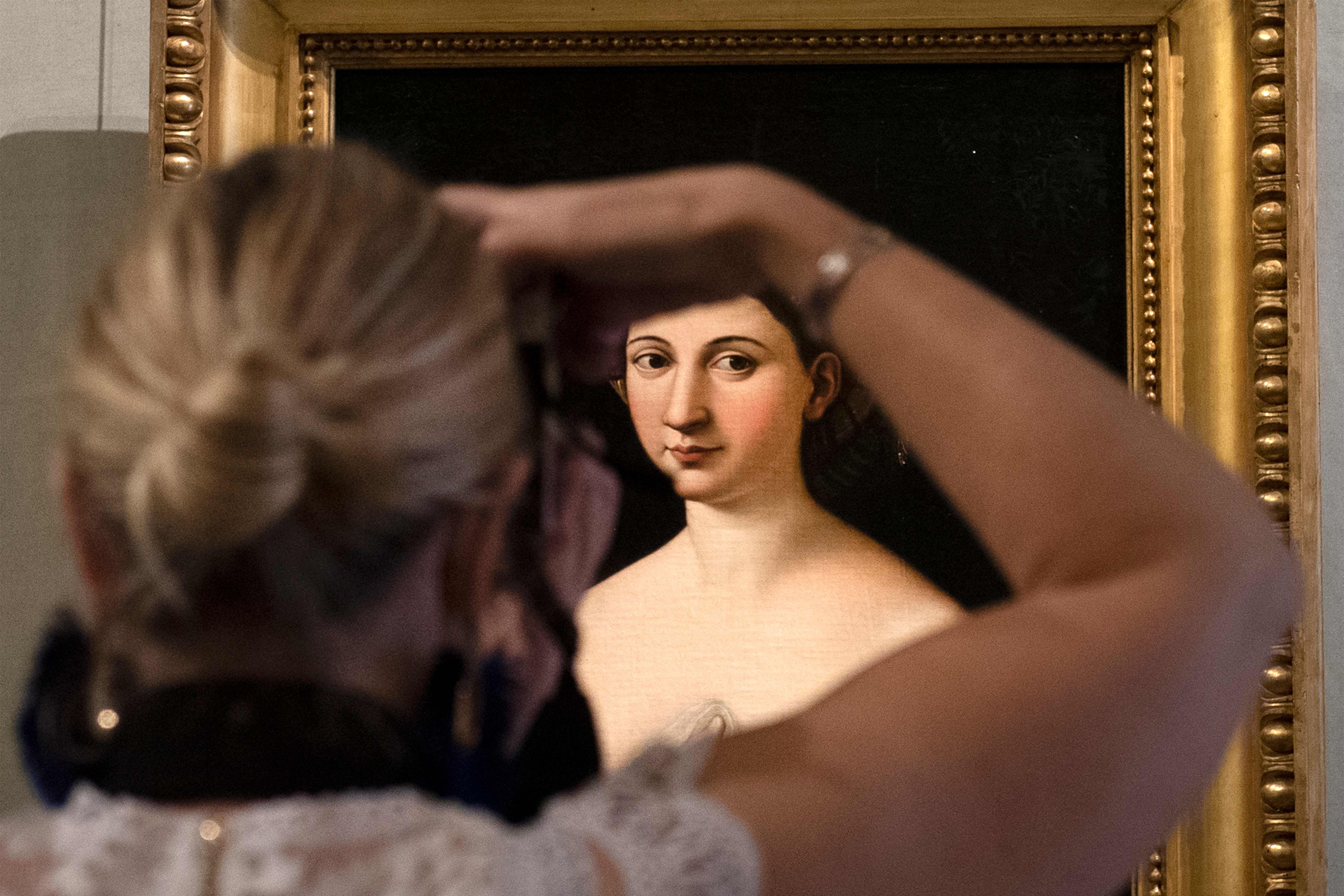 Pengunjung memotret lukisan Portrait of a Young Woman karya seniman Raphael di museum Galleria Borghese di Roma, Italia (19/5).