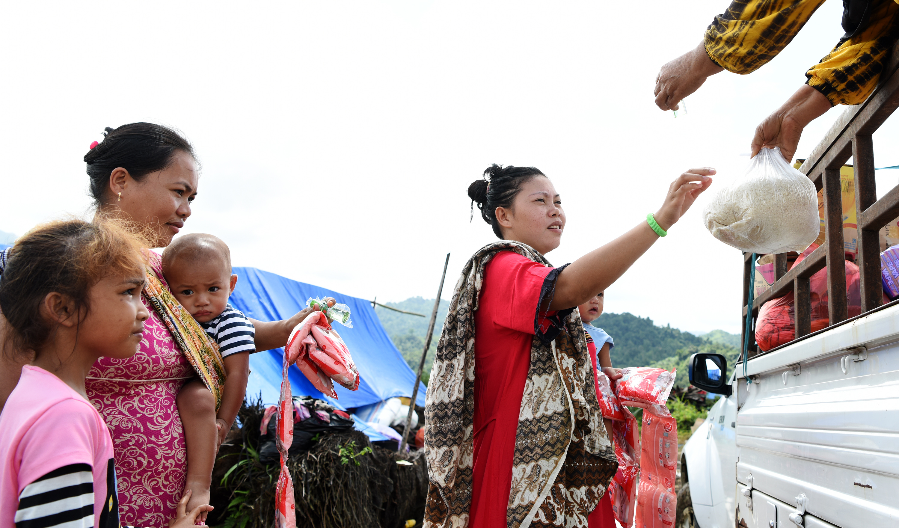 Pengungsi mengambil bantuan di tempat pengungsian di Desa Meli Masamba, Kabupaten Luwu Utara, Sulawesi Selatan Selasa (21/07/2020).