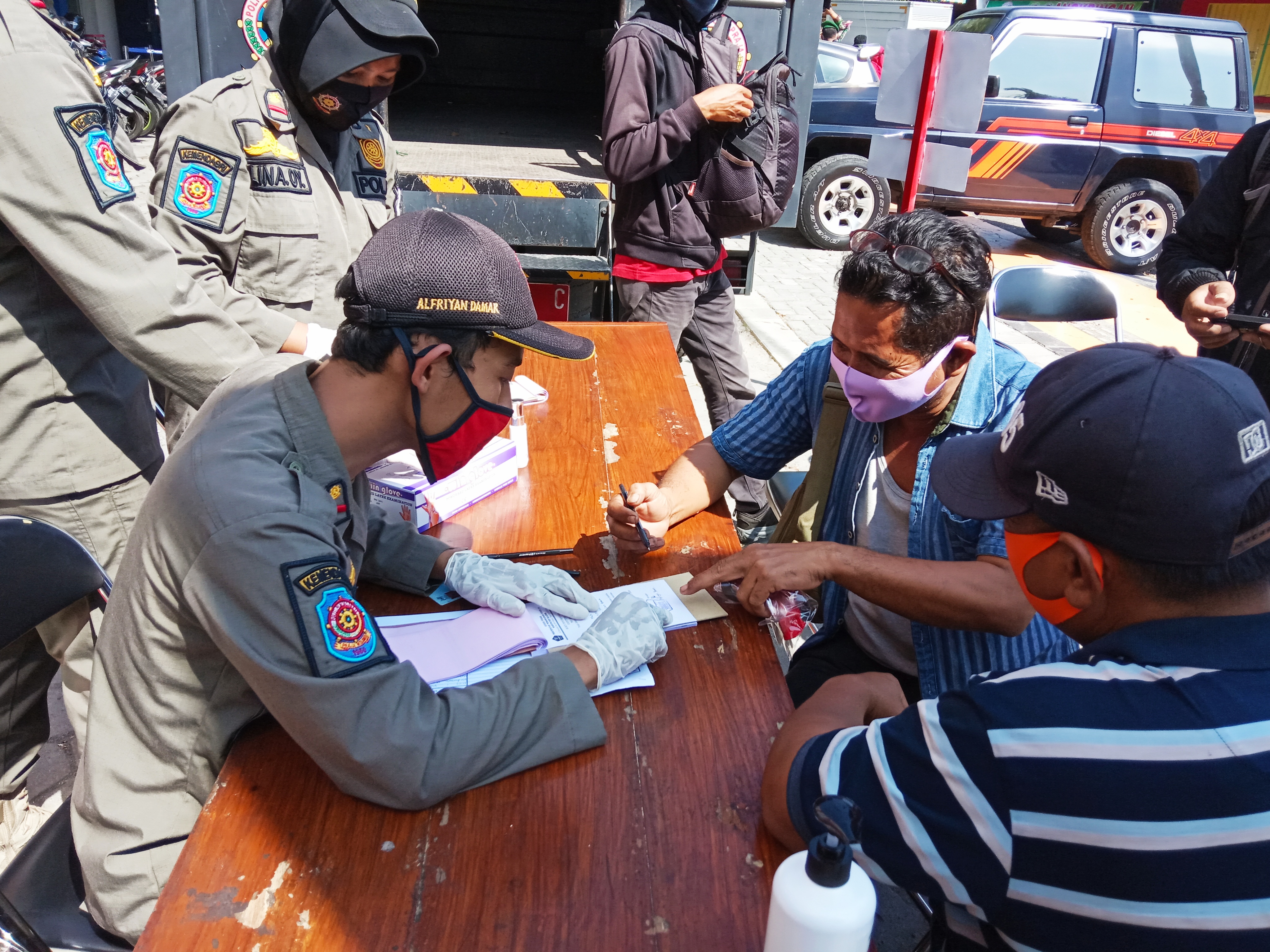 Warga terjaring operasi telah memakai masker saat mengambil KTP yang ditahan petugas, Rabu (1/7/2020)