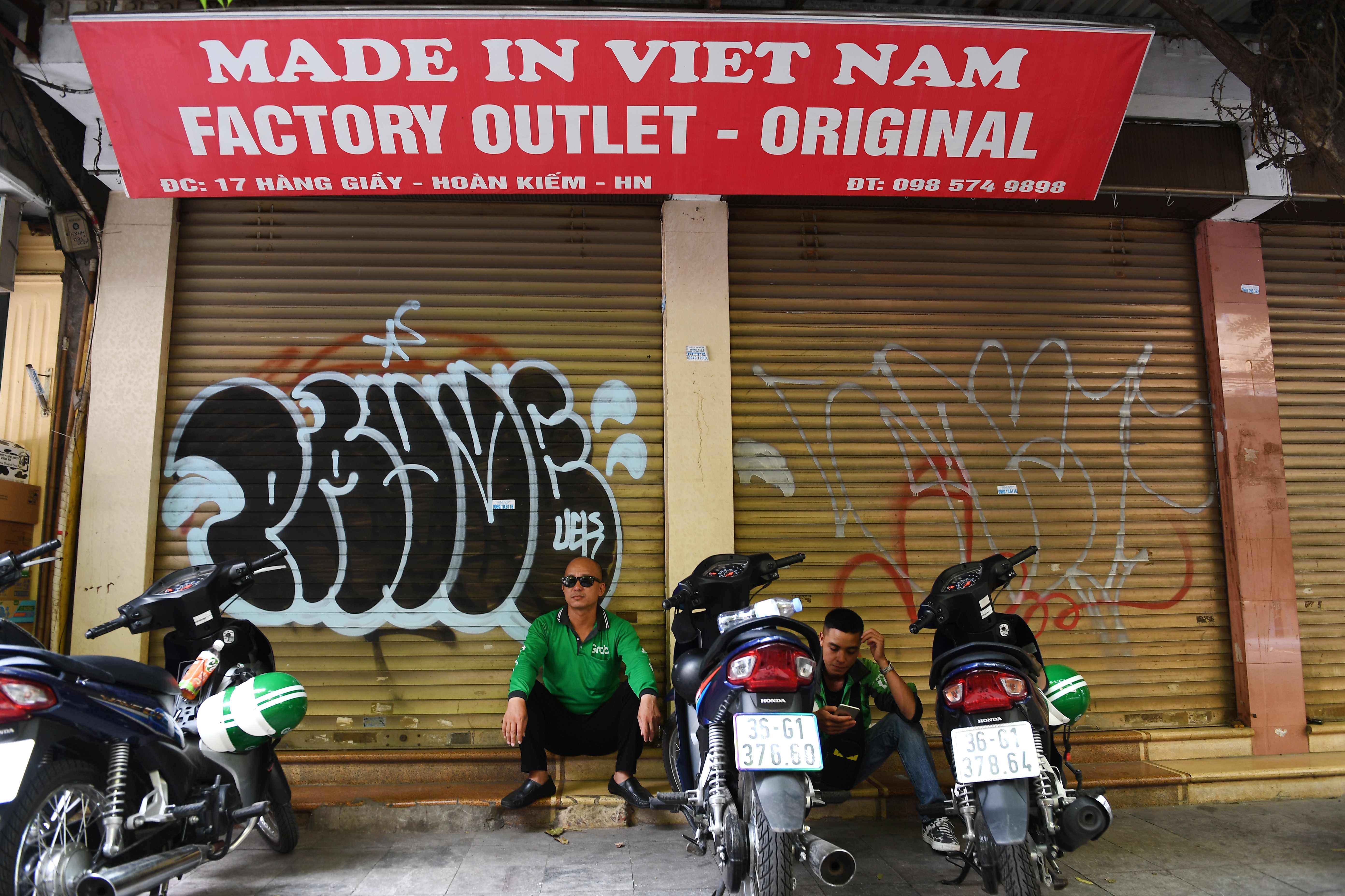Pengemudi ojek daring di Vietnam menunggu order dari konsumen.