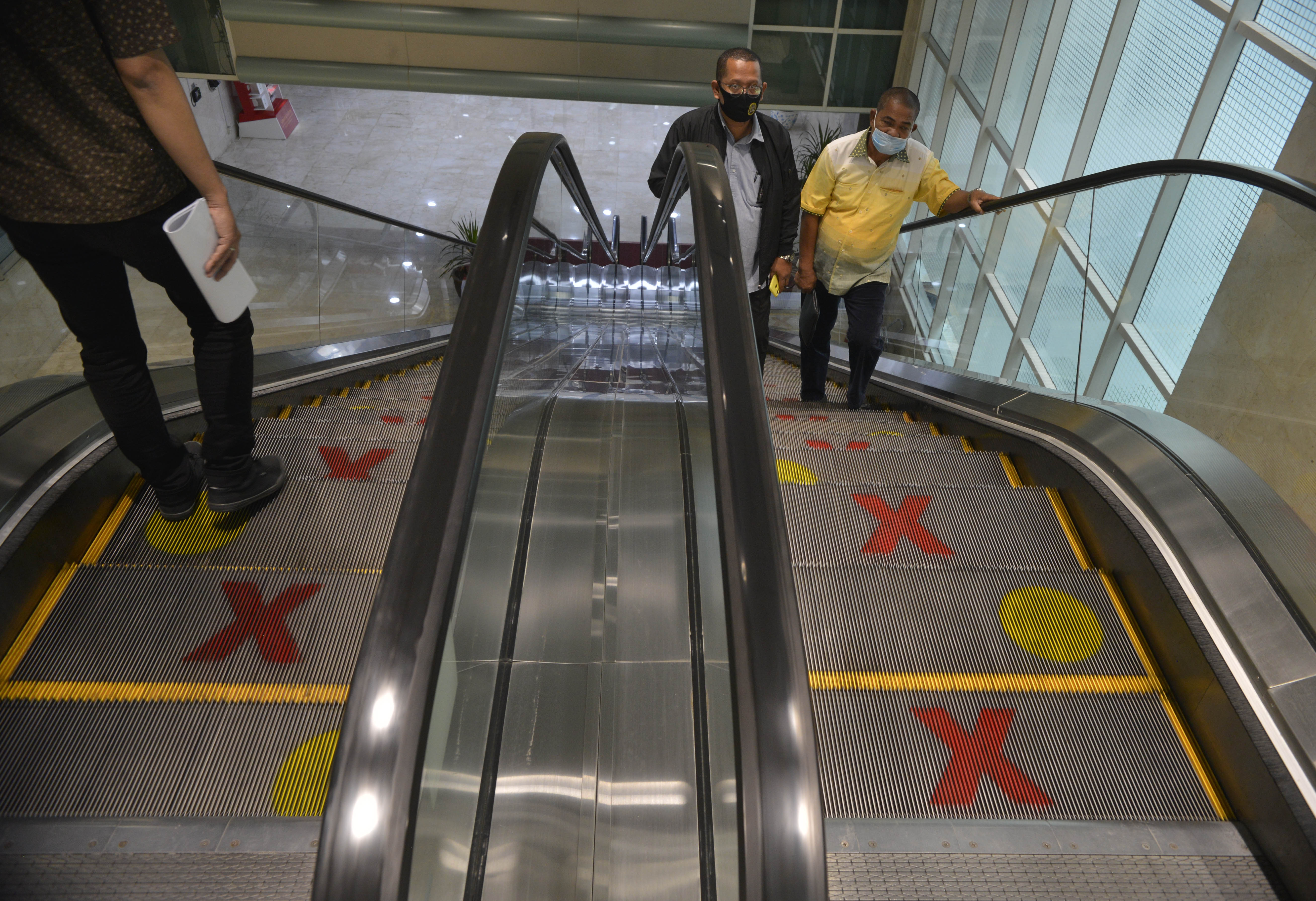 Eskalator di Gedung Nusantara II Komplek Parlemen Senayan Jakarta diberi tanda silang dan lingkaran untuk penanda atau rambu jaga jarak. 