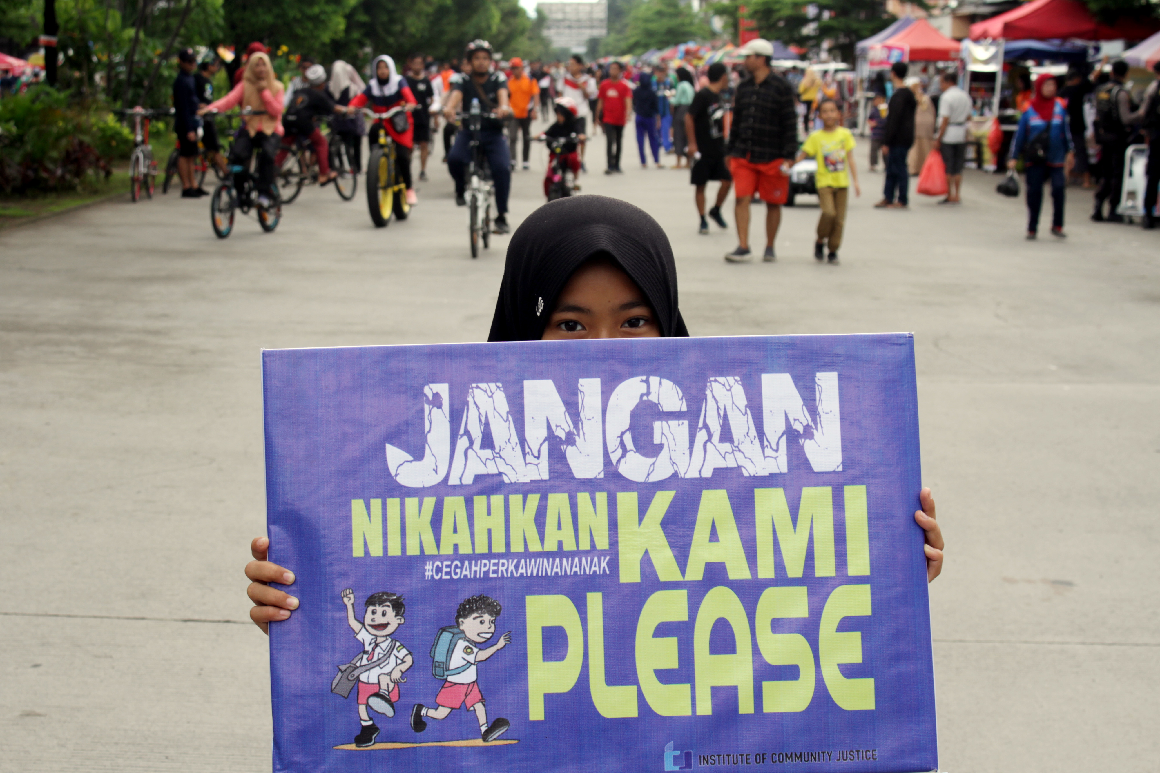 Seorang anak membawa poster saat aksi peringatan Hari Perempuan Internasional di Makassar, Sulawesi Selatan, Minggu (8/3/2020).