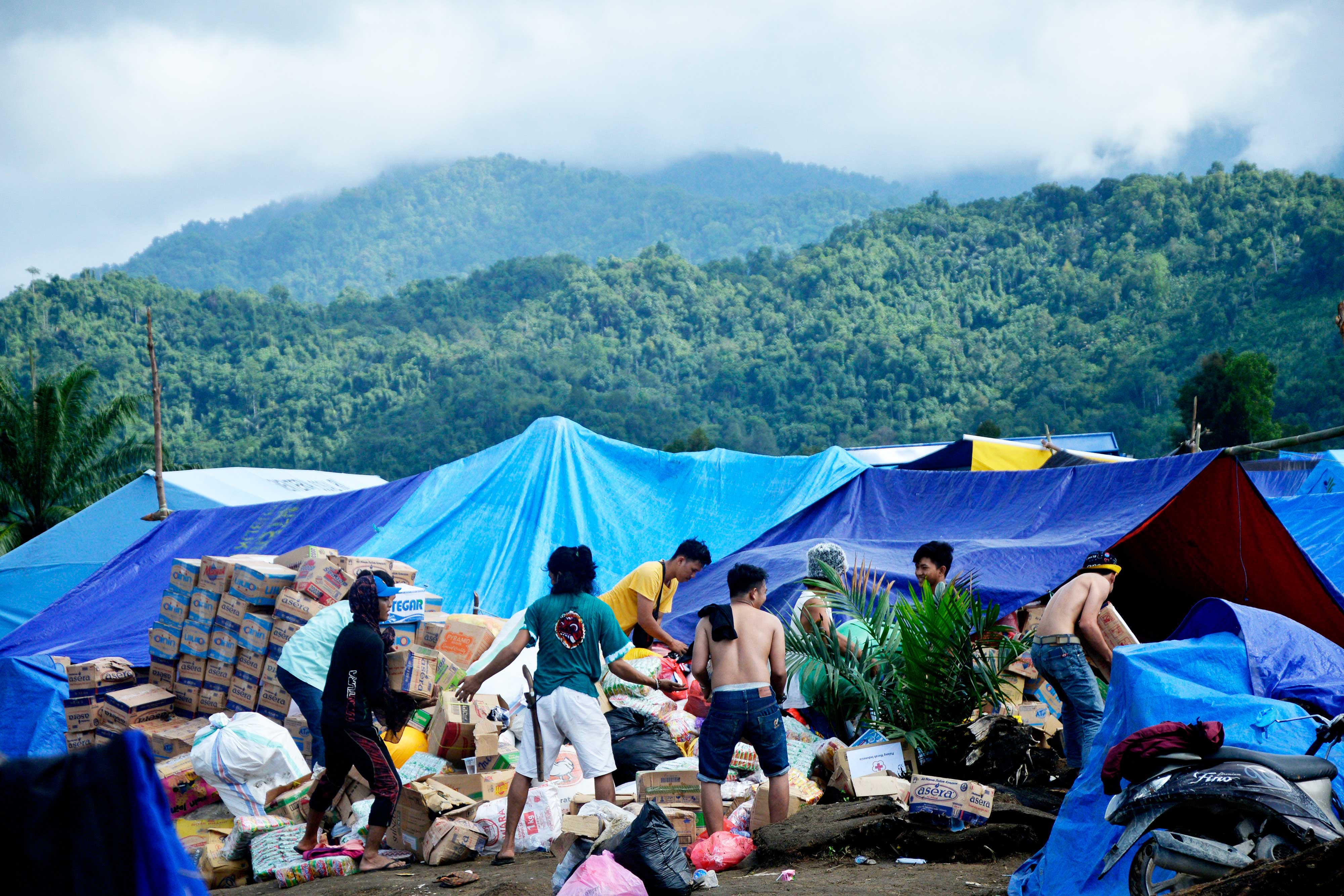 Warga korban banjir bandang bersama relawan mengatur bantuan logistik di pengungsian kawasan perbukitan di Desa Meli, Luwu Utara, Sulsel.