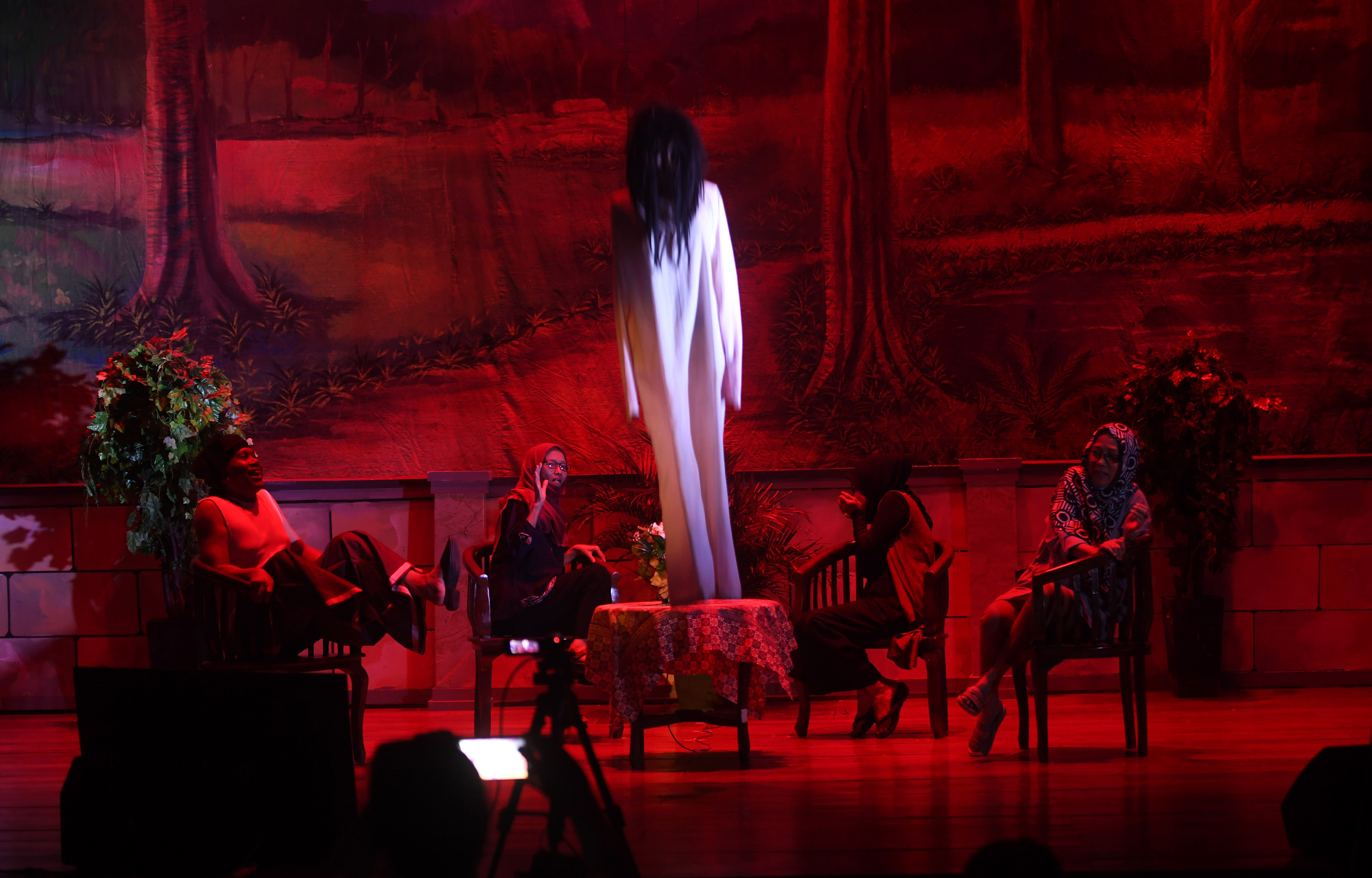 Ilustrasi pekerja seni menampilkan drama secara daring cuplikan cerita kuntilanak sumur tua.