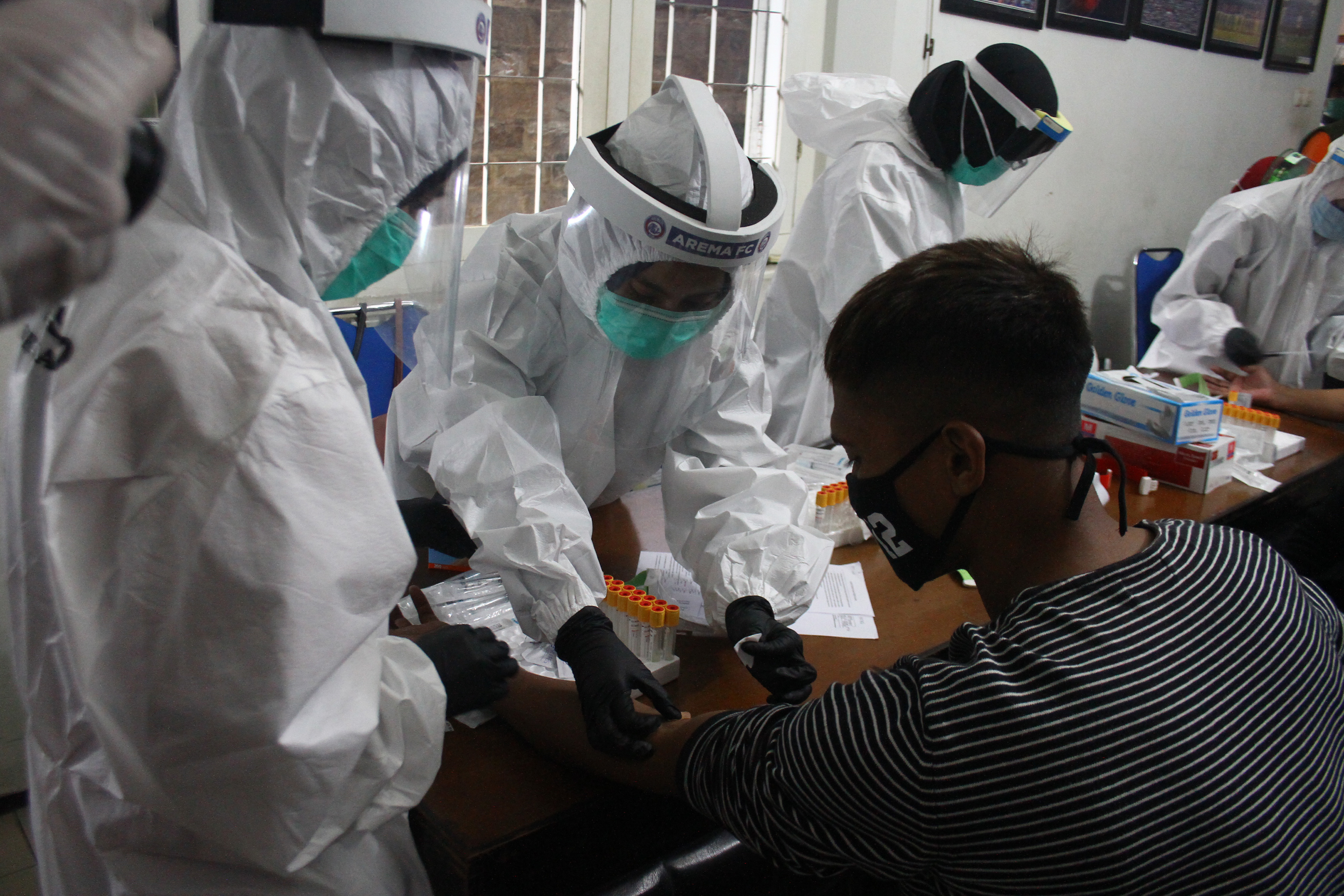 Petugas mengambil sampel darah pemain salah satu pemain Arema FC, rapid test di Malang, Jumat (17/7)