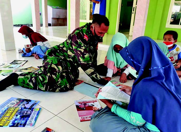 Sertu Tarmudji, personel Babinsa, tengah menerangkan isi buku kepada anak-anak di Desa Majalaya, Karawang, Jawa Barat, kemarin.