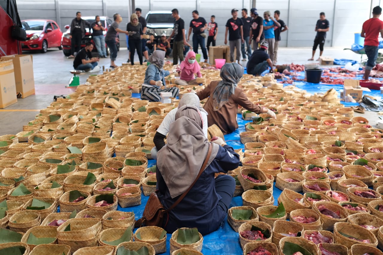 Petugas tengah memasukan daging kurban ke dalam besek untuk kemudian dikasih langsung ke rumah-rumah warga.