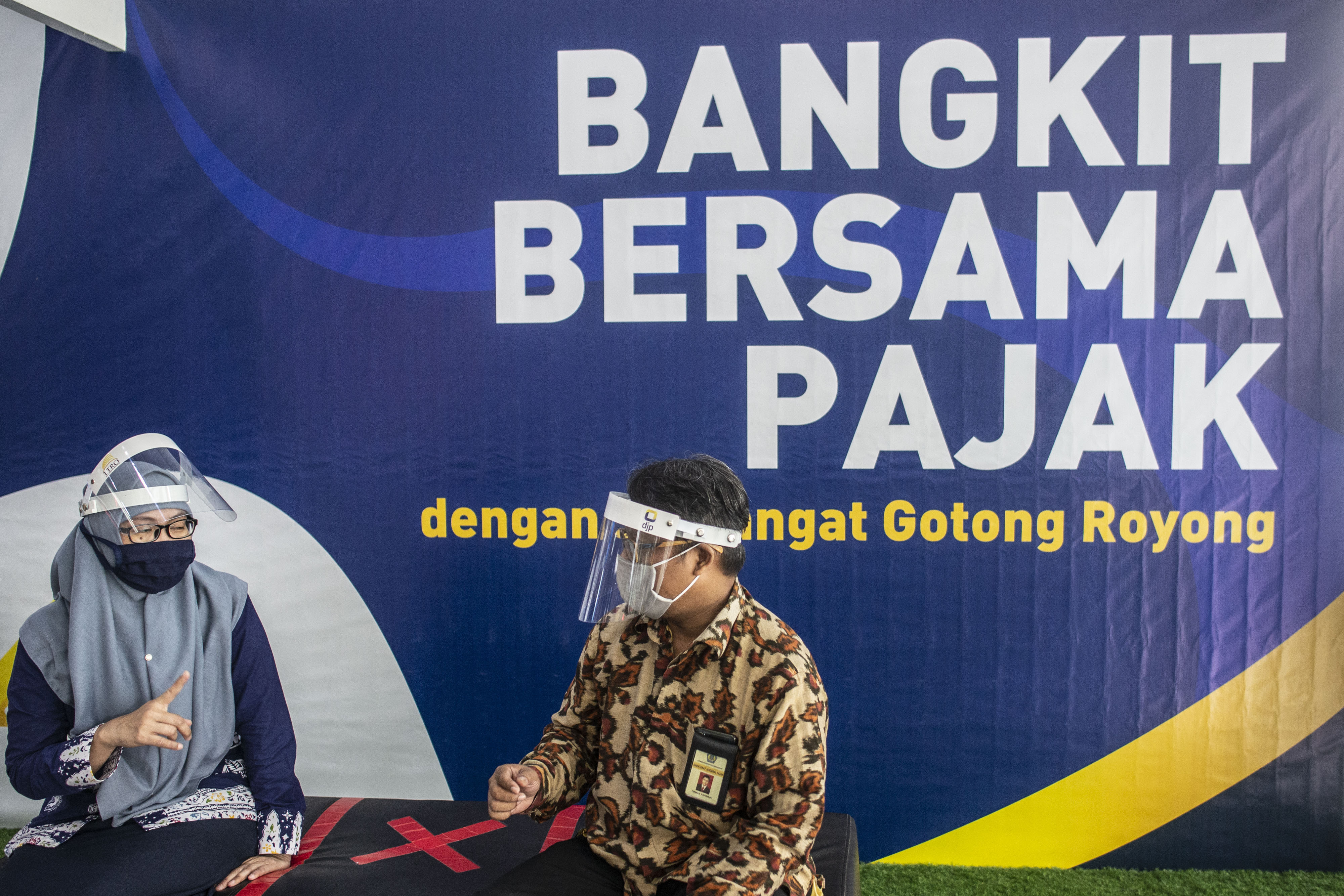 Dua petugas pajak berbincang saat peringatan Hari Pajak 2020 di Kantor Direktorat Jenderal Pajak, Jakarta, Selasa (14/7).
