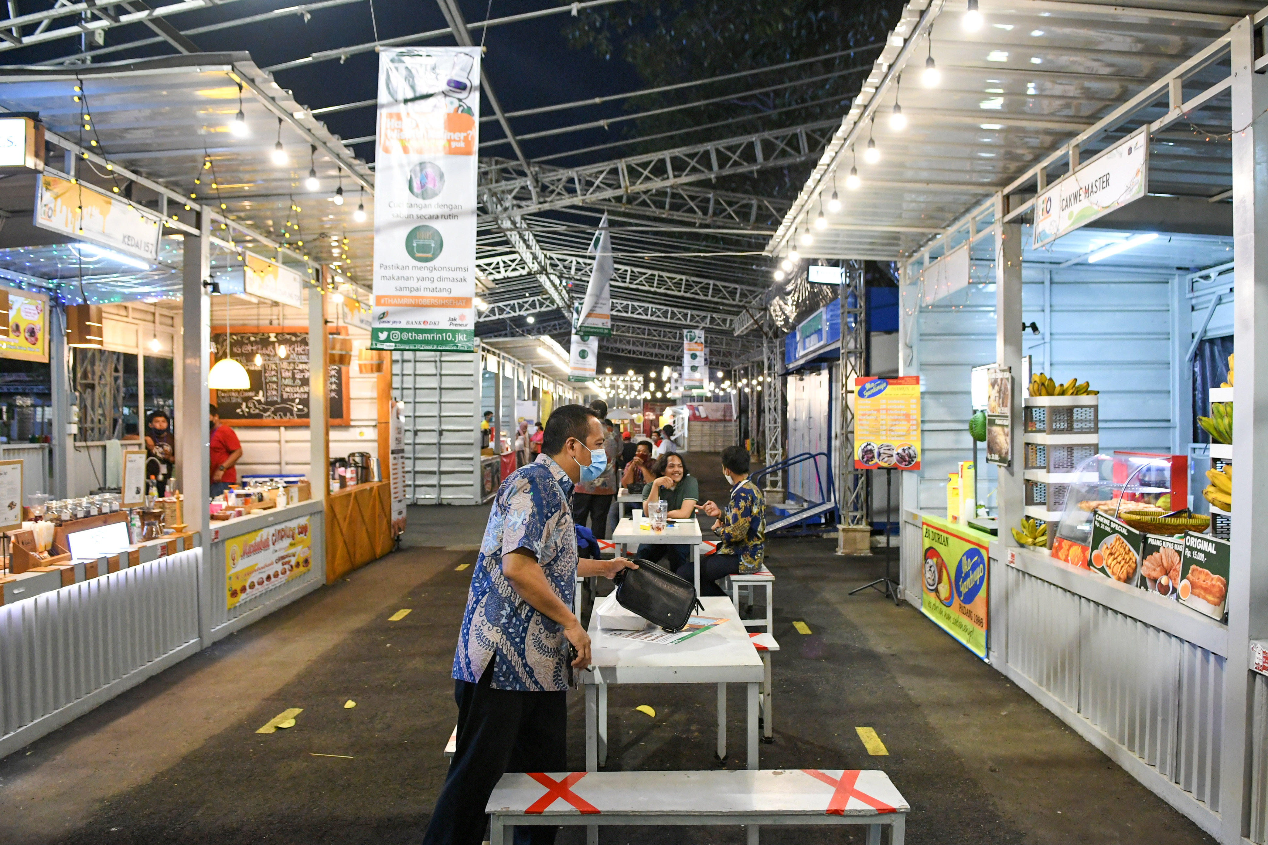 Warga dengan mengenakan masker berkunjung ke pusat kuliner Thamrin 10, kawasan Thamrin, Jakarta, saat hari pertama dibuka, Senin (15/6).