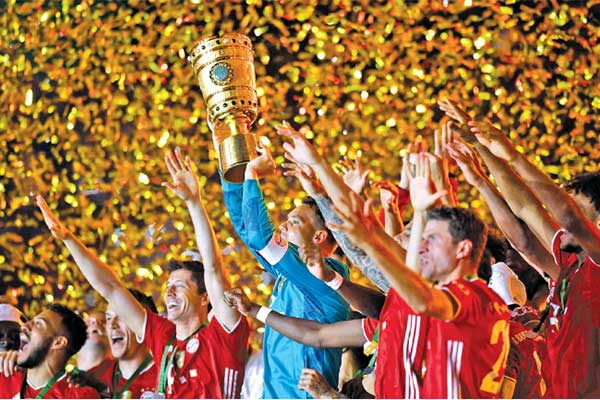Kapten Bayern Muenchen Manuel Neuer mengangkat trofi Piala Jerman