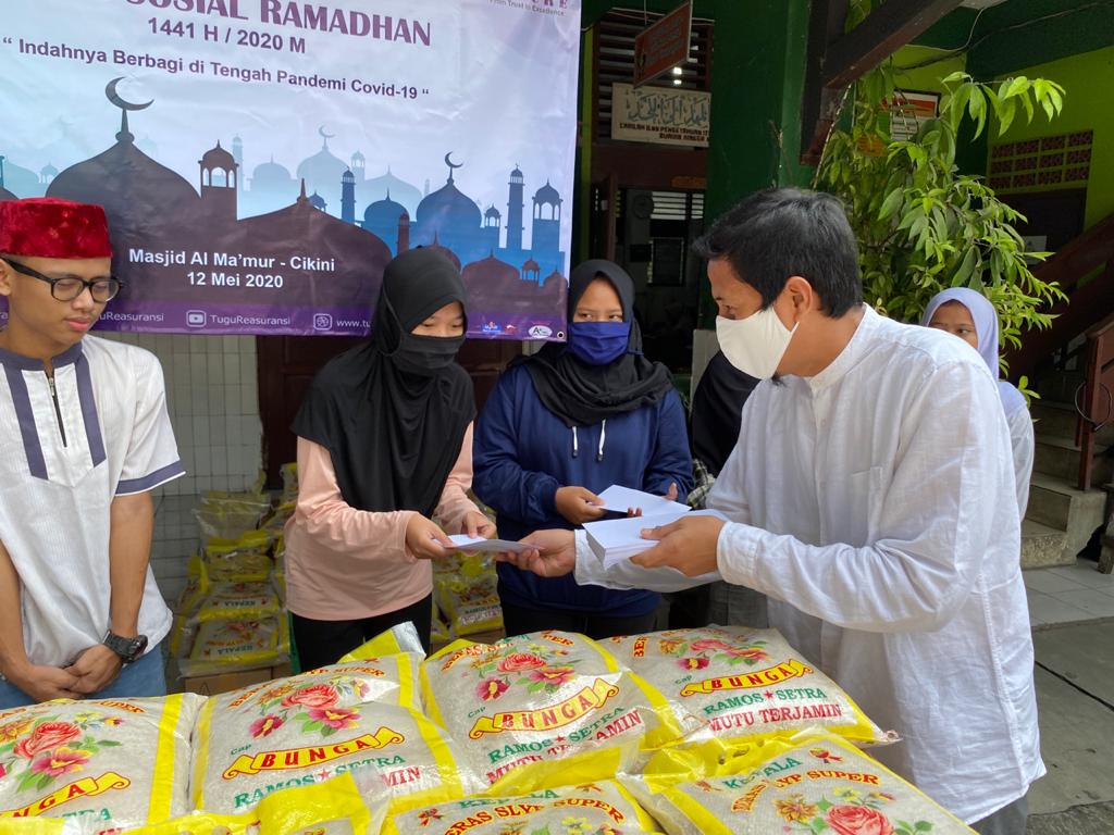 Presdir Tugure Adi Pramana (kanan) menyerahkan santunan uang tunai kepada salah satu warga di Masjid Al-Ma'Mur di Cikini, Jakarta Pusat. 