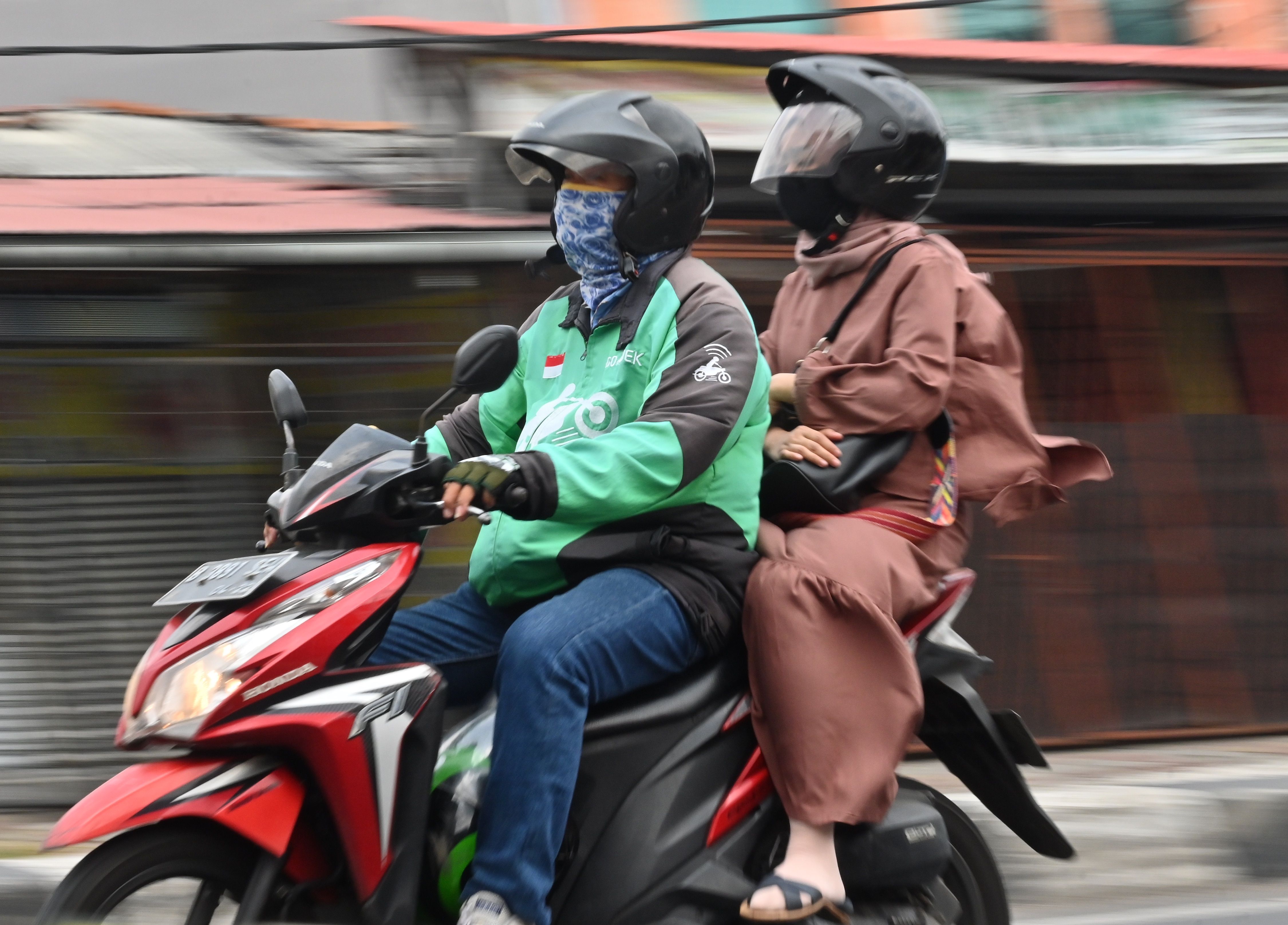 Seorang pengemudi Gojek membawa penumpang di Jakarta.