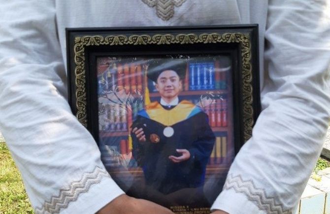 Foto Yodi Prabowo yang dipegang keluarga saat pemakaman.