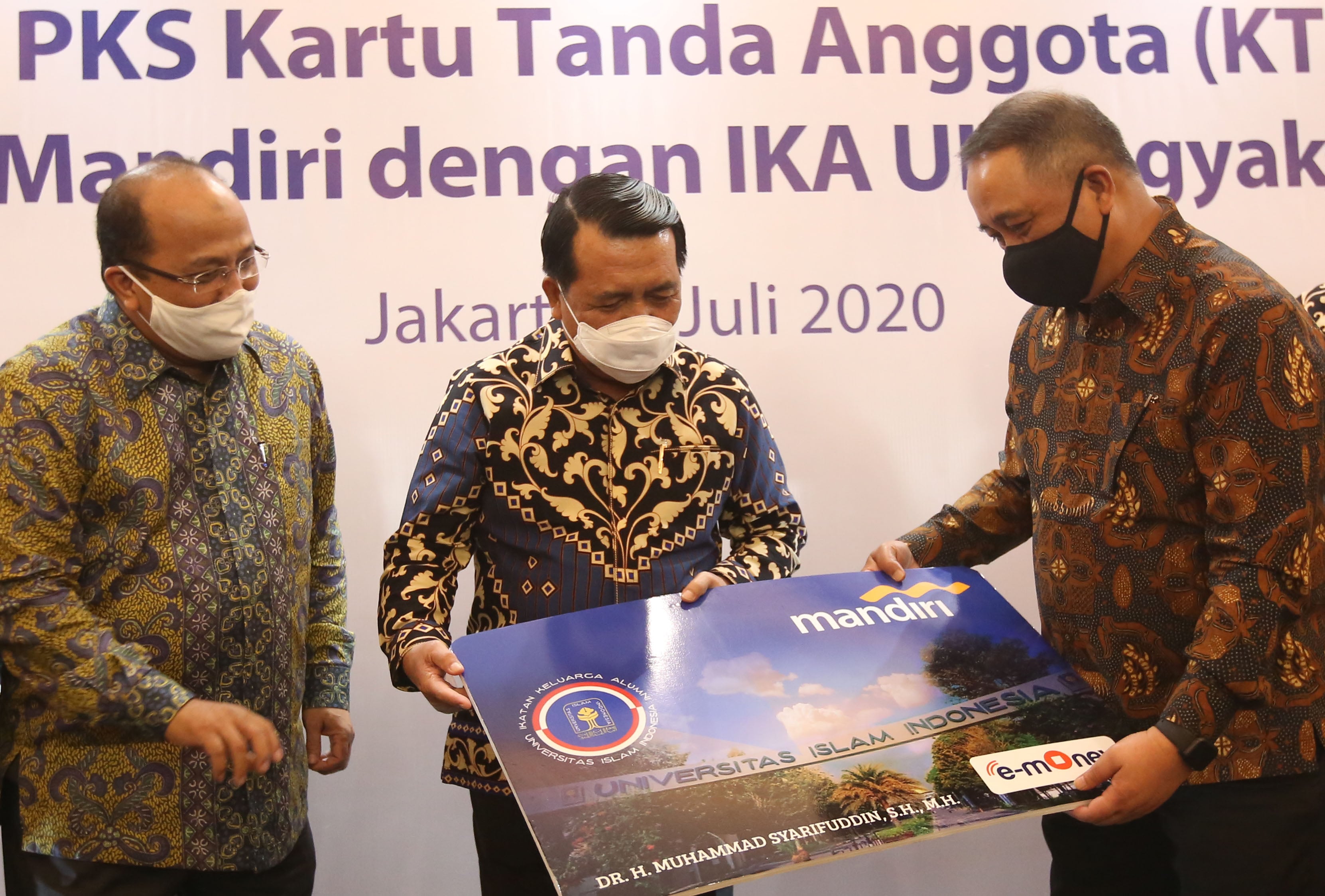 Dirut Bank Mandiri Royke Tumilaar (kanan) memberikan secara simbolis model Kartu Tanda Anggota (KTA) IKA UII Co Brand Mandiri e-money.