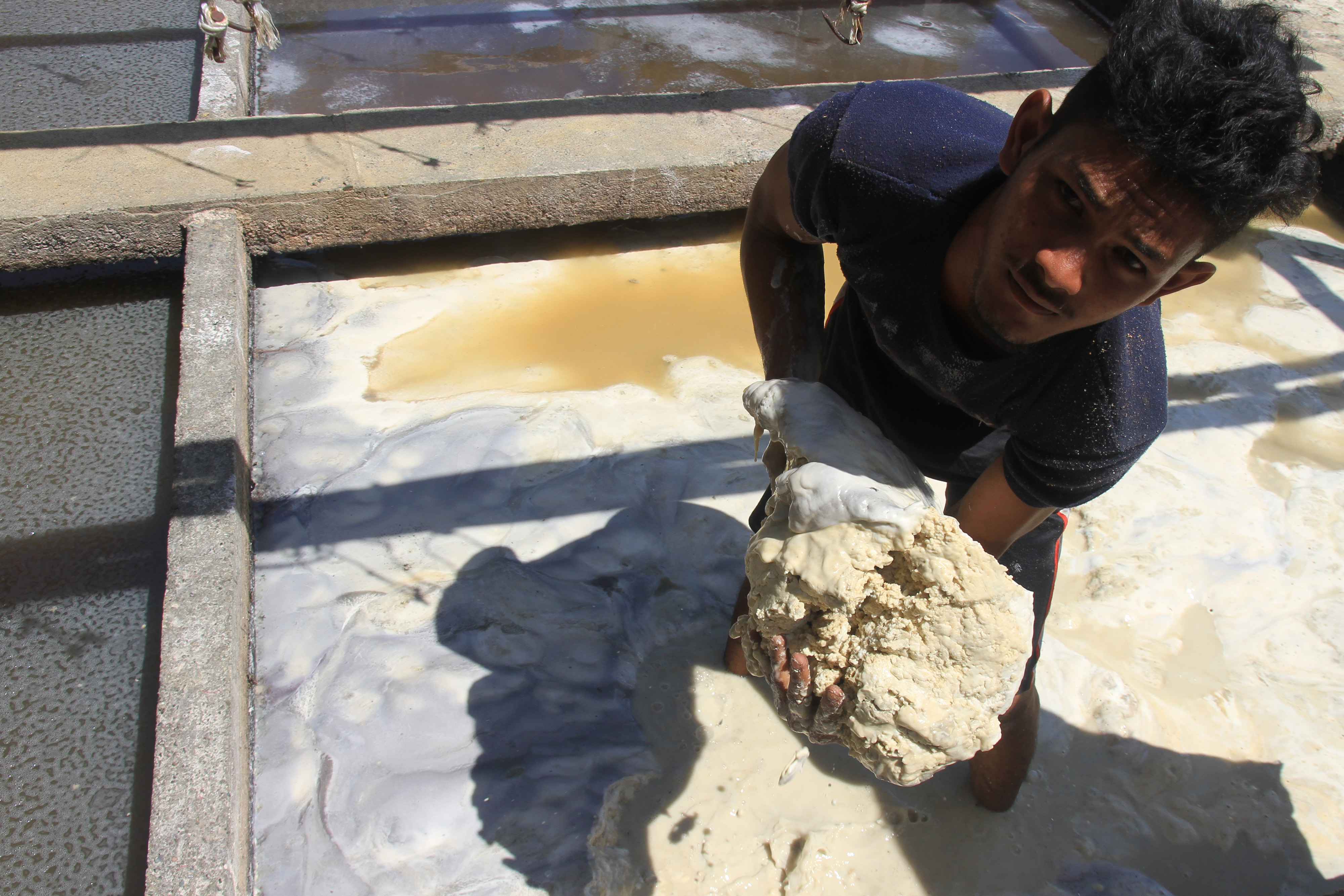 Pekerja mengumpulkan endapan tepung sagu saat proses pengolahan di tempat pembuatan tepung sagu Desa Pasi Aceh Tunong, Aceh Barat.