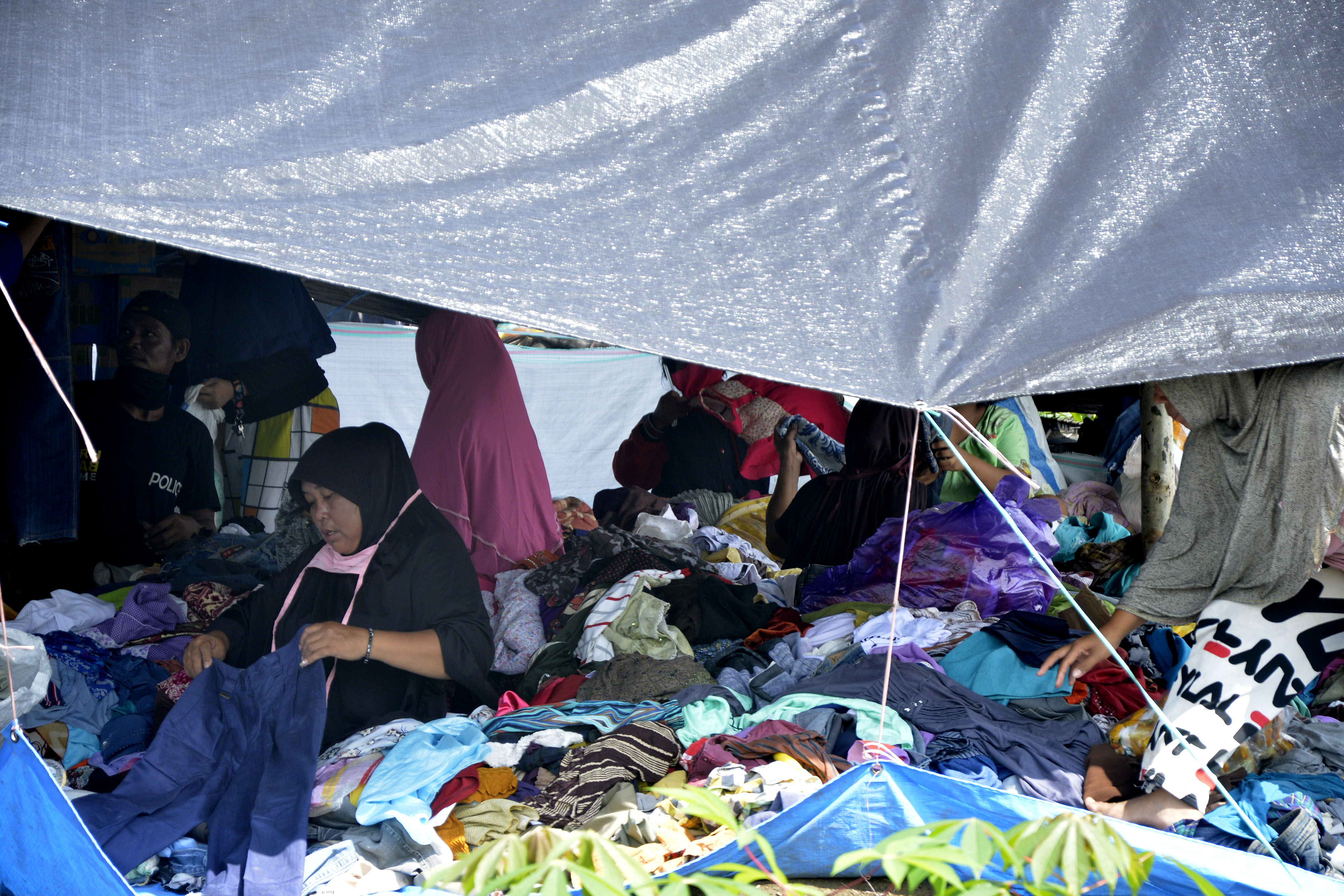  Warga korban banjir bandang memilih bantuan pakaian layak pakai di sekitar pengungsian Perbukitan Desa Meli, Baebunta, Luwu Utara.