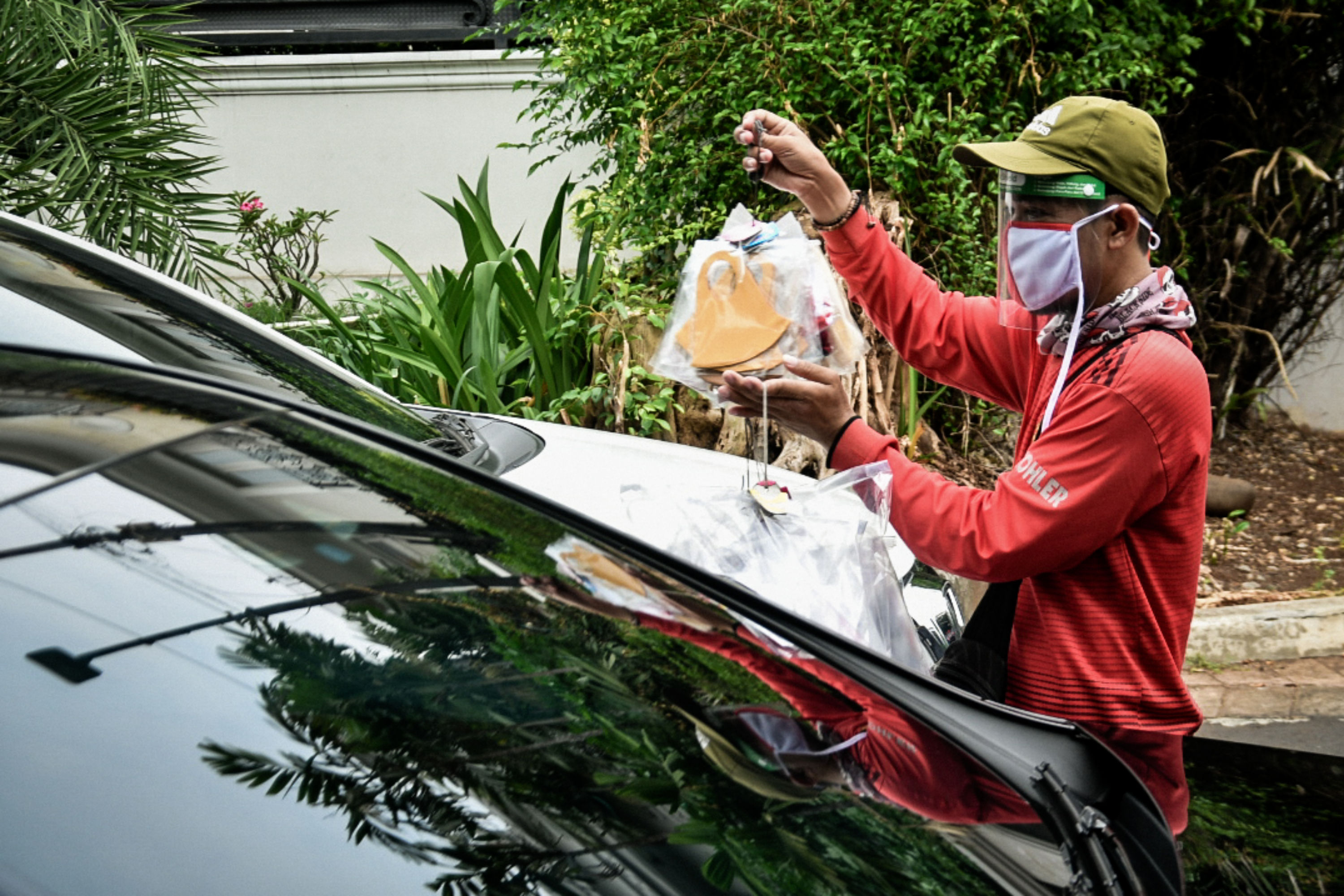  Pedagang menjajakan dagangannya berupa face shield dan masker pada pengendara di kawasan Pondok Indah, Jakarta Selatan.