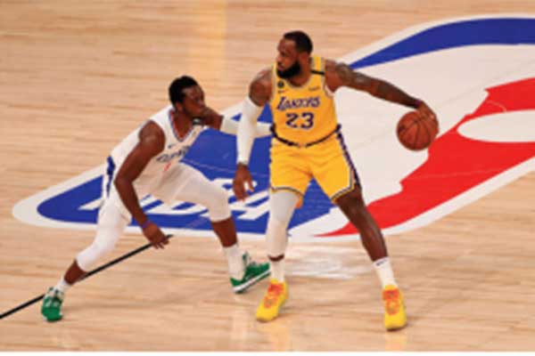 Pemain Los Angeles Lakers LeBron James (kanan) dihadang pemain Los Angeles Clippers Reggie Jakson (kiri) 