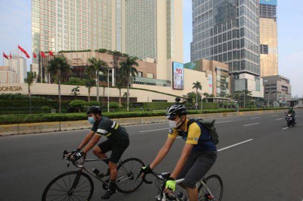Warga berolahraga menggunakan sepeda di kawasan Bundaran HI, Jakarta.