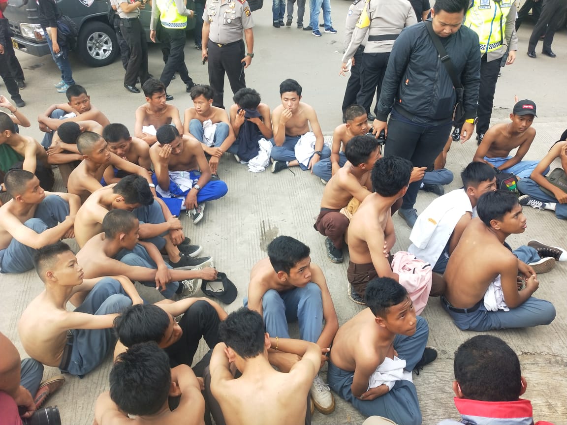 Petugas mengamankan anak-anak pelajar yang akan melakukan demo. Pelibatan anak dalam demo melanggar UU Perlindungan anak