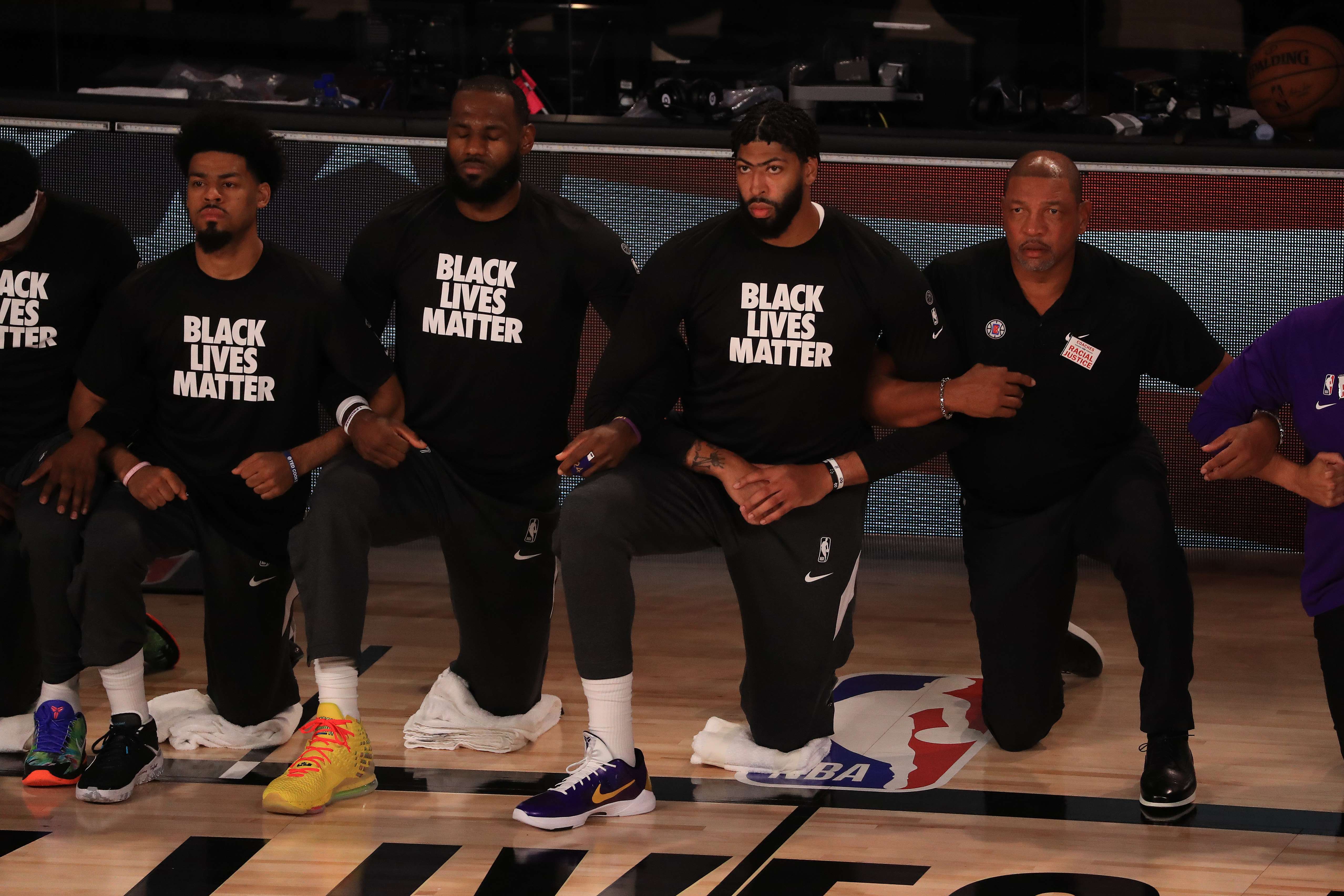  Pemain Los Angeles Lakers dalam balutan kaos bertuliskan Black Lives Matter berlutut sebelum pertandingan dimulai