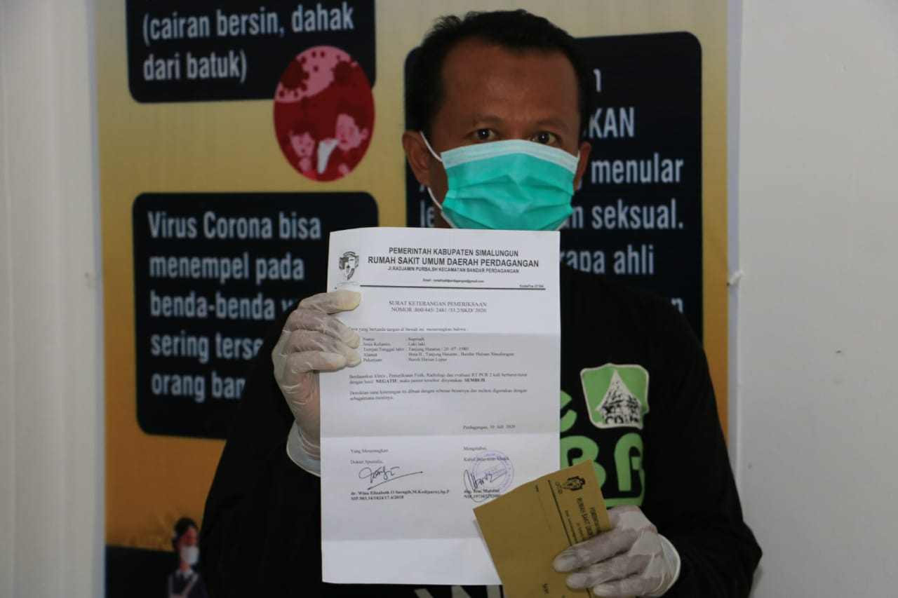 Seorang pasien yang telah dinyatakan sembuh memperlihatkan surat keterangan sembuh dari RSUD Perdagangan Simalungun.