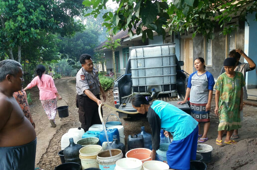 Anggota Polsek Cineam, Polres Tasikmalaya Kota mendistribusikan air bersih bagi warga di Sukahurip, Cineam, Tasikmalaya,Minggu (14/6).
