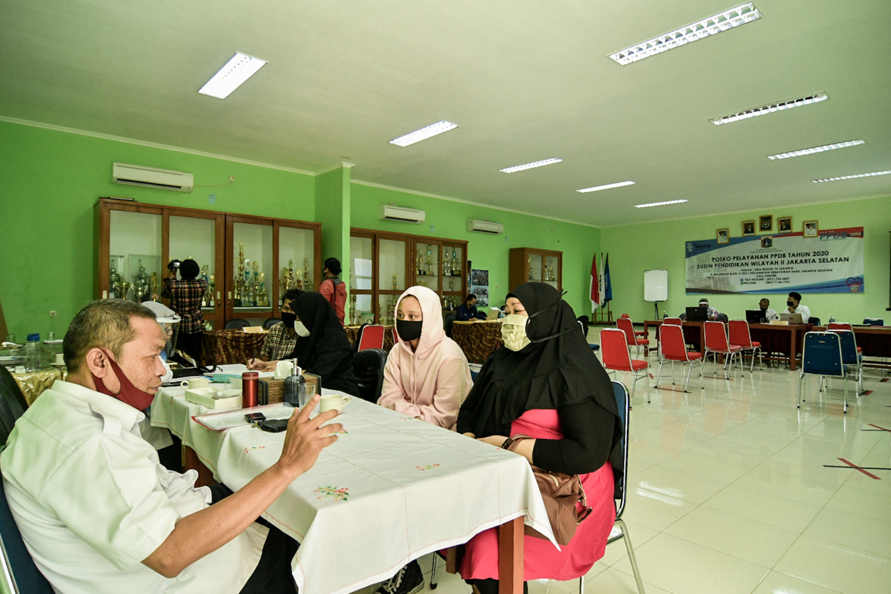  Petugas melayani orang tua siswa di posko Penerimaan Peserta Didik Baru (PPDB) di SMA Negeri 70 Jakarta.