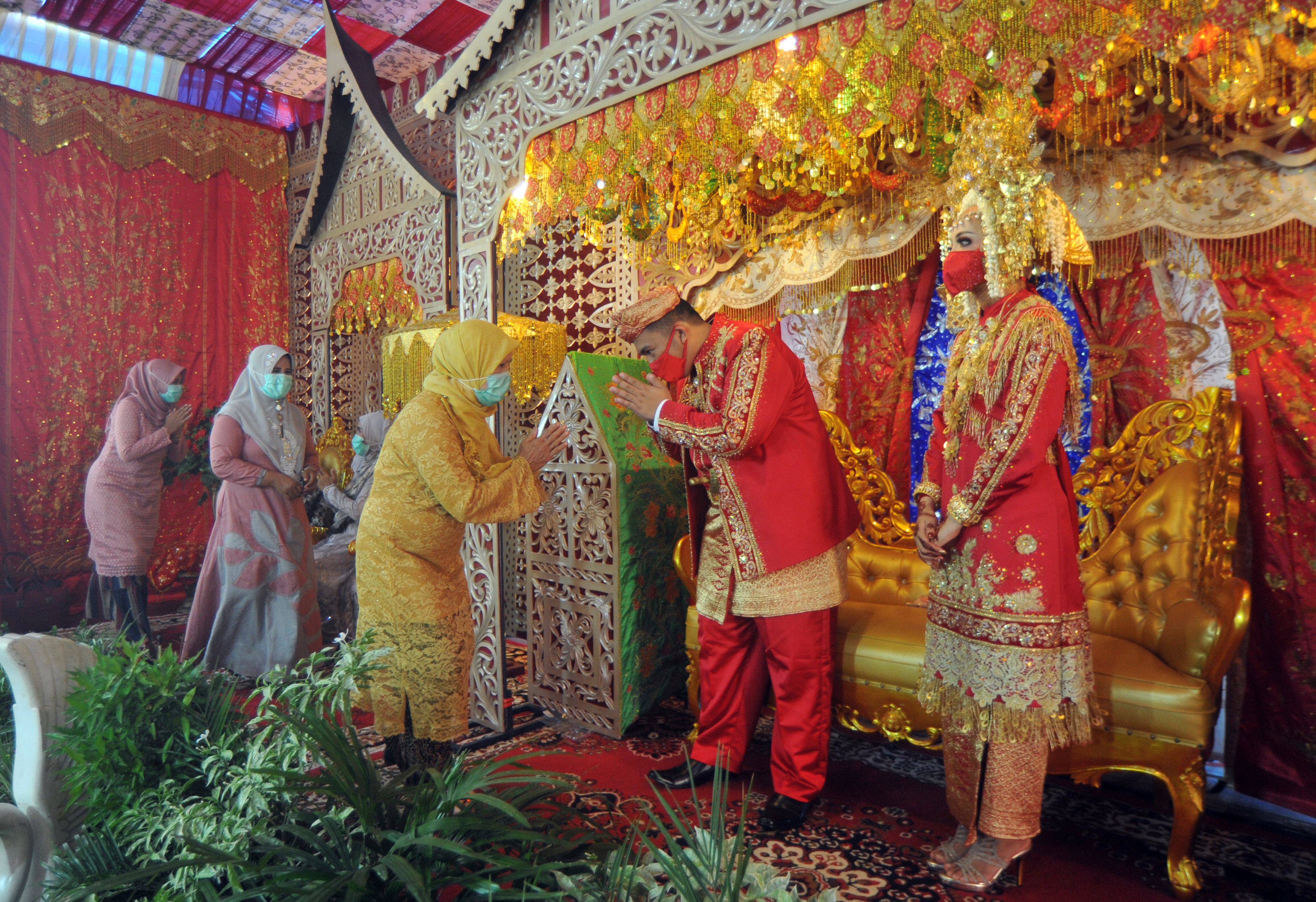 Pasangan pengantin Mizwar dan Ines di Padang menerima tamu dengan bersalaman dari jauh sesuai protokol kesehatan 