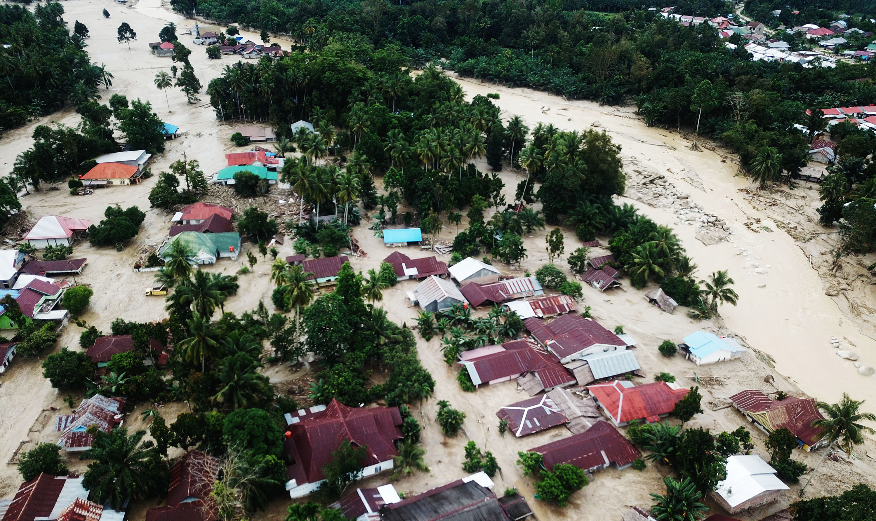 Foto udara kondisi perkampungan tertimbun lumpur akibat terjangan banjir bandang di Desa Radda, Kabupaten Luwu Utara, Sulawesi Selatan.