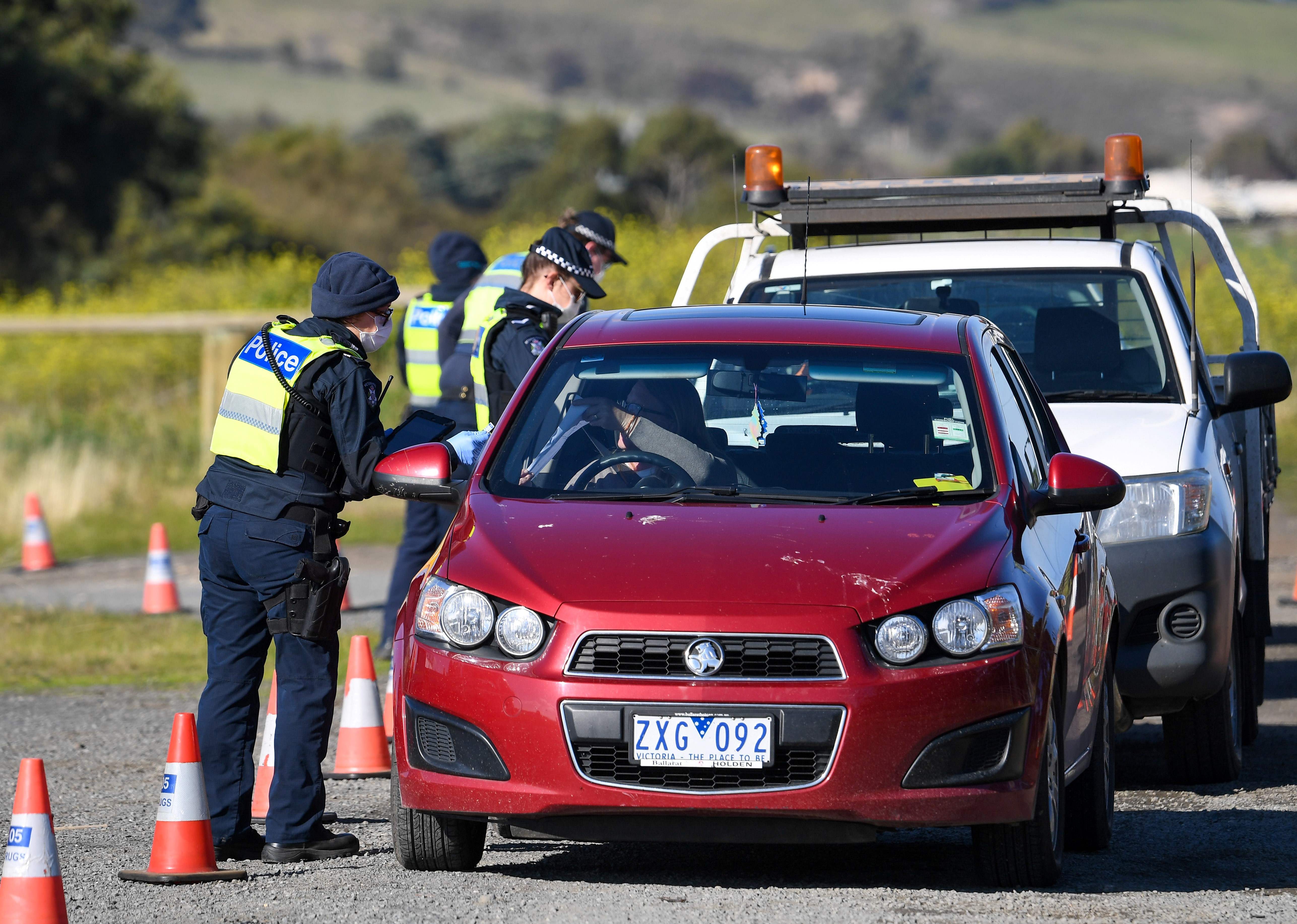 Polisi memeriksa mobil yang akan memasuki Melbourne di hari pertama lockdown covid-19.