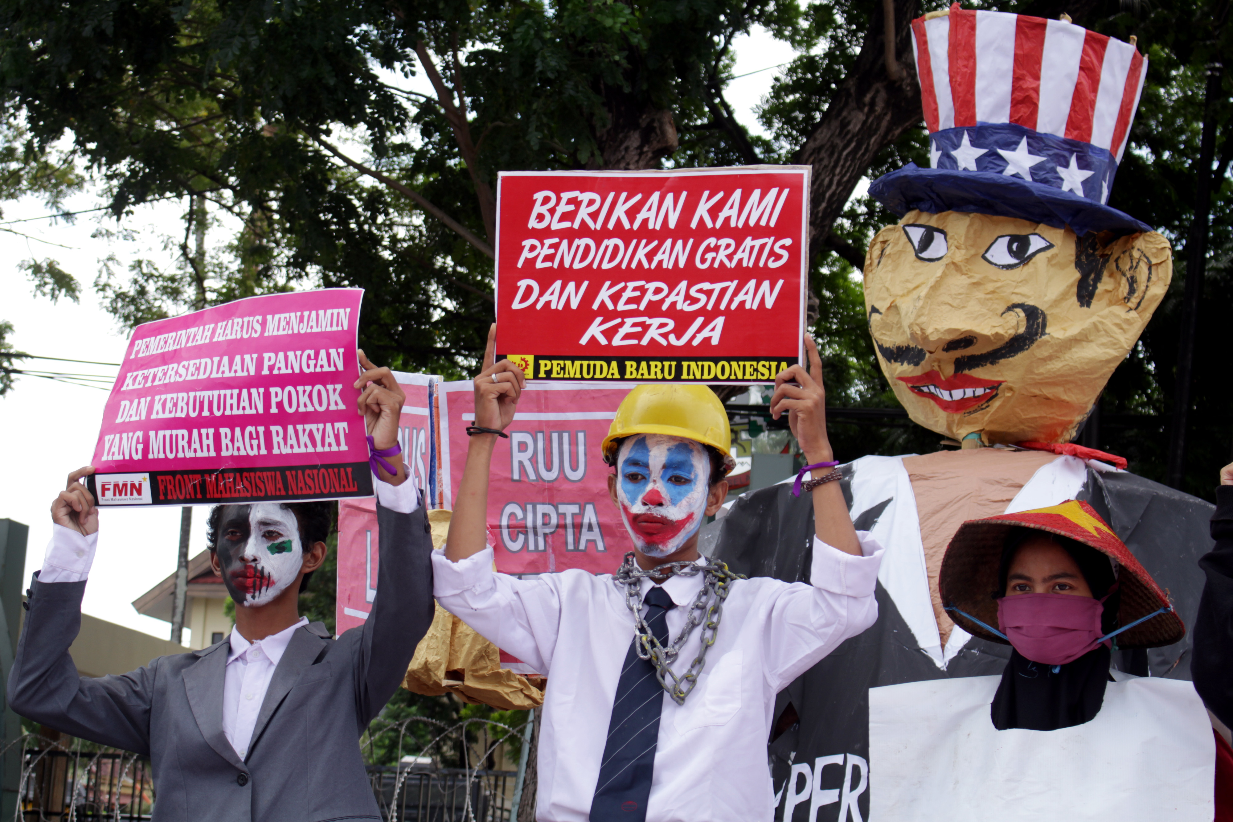 Demonstran membawa poster saat melakukan aksi unjuk rasa di depan Kantor DPRD Sulsel di Makassar, Sulawesi Selatan, Kamis (16/7/2020)