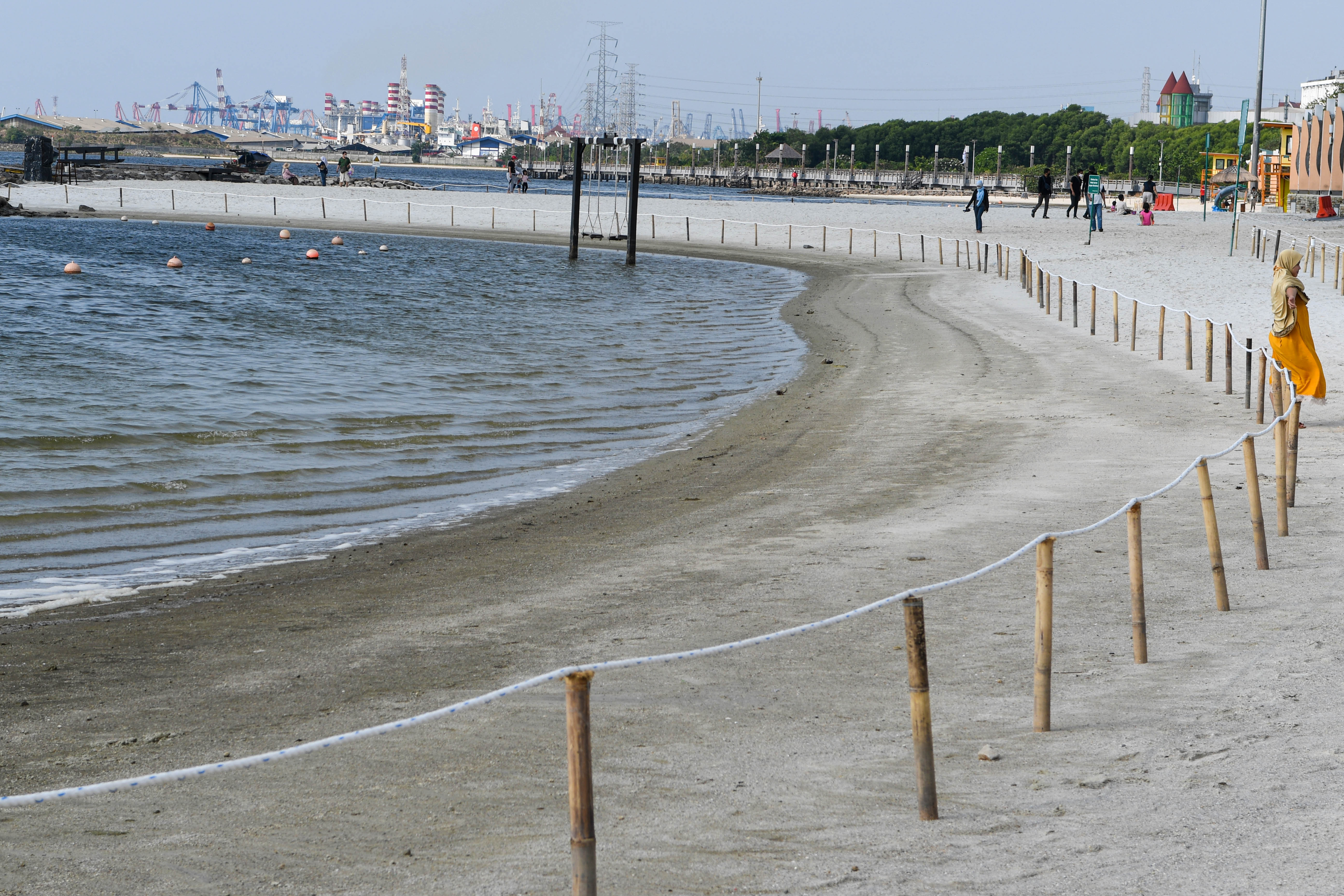 Pengunjung berjalan di Pantai Festival Taman Impian Jaya Ancol, Jakarta,