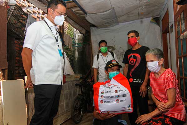 Menteri Sosial Juliari P Batubara (kiri) saat memberikan paket bantuan kepada warga terdampak COVID-19 di Beji, Depok, Jawa Barat