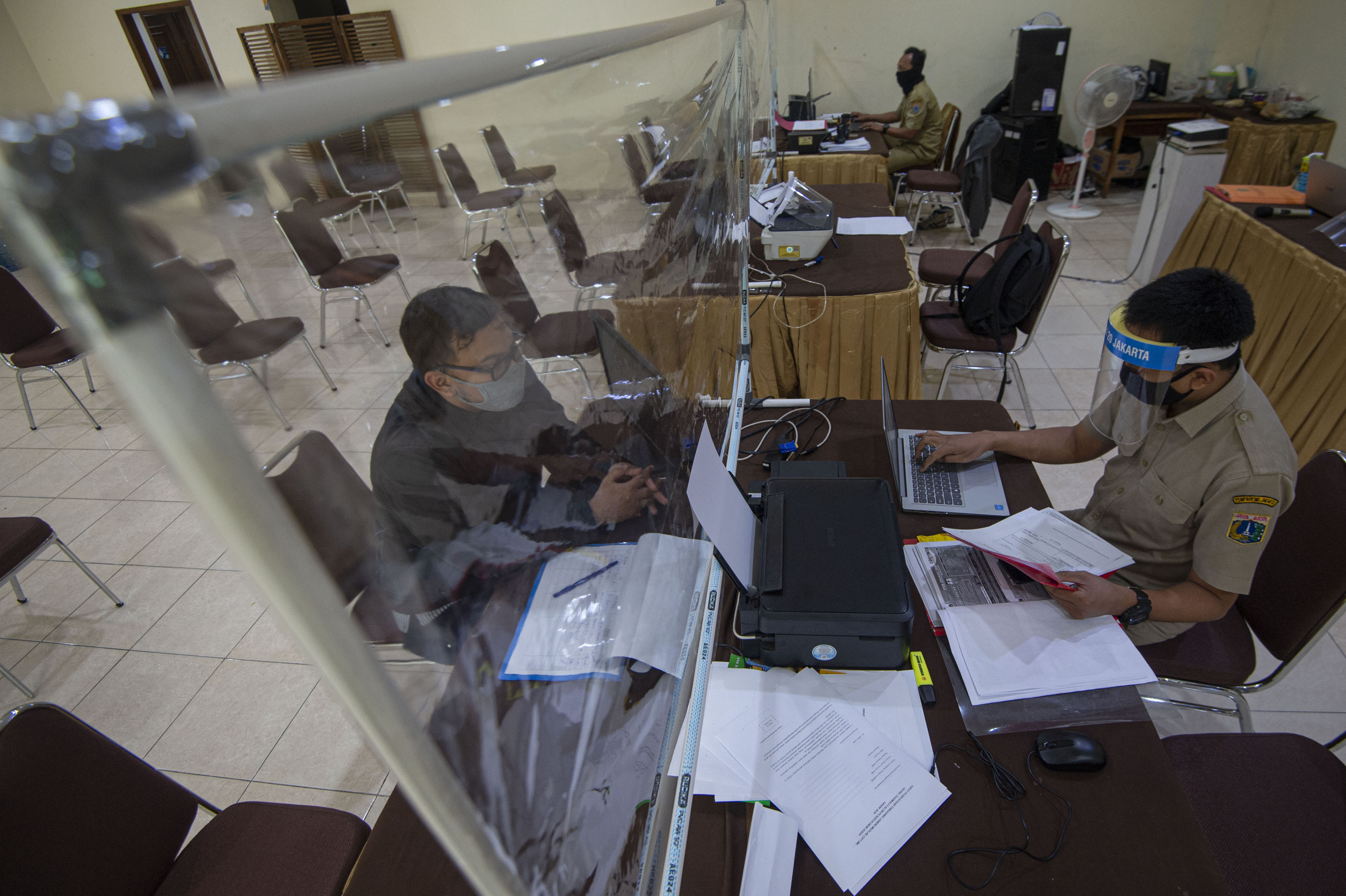 Petugas melayani orang tua murid yang lolos PPDB 2020/2021 jalur zonasi di Posko Pelayanan PPDB Jakarta Pusat (30/6/2020)