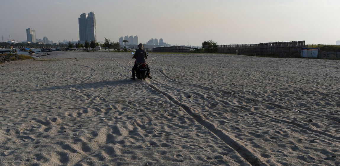 : Pengendara melintas di atas lahan hasil reklamasi Ancol di Jakarta, Sabtu (11/7/2020). 