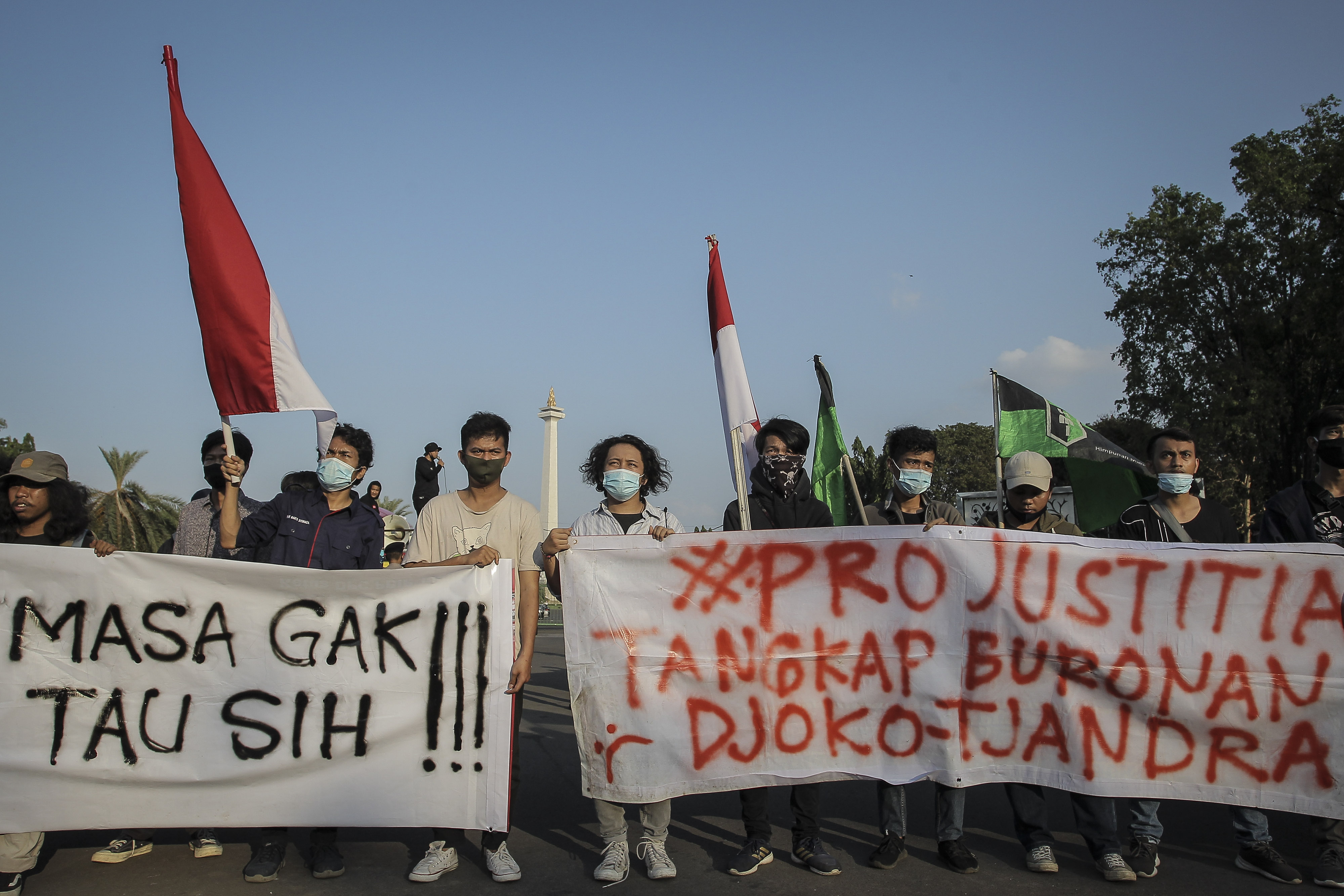 Massa aksi membentangkan spanduk saat menggelar unjuk rasa di Taman Aspirasi, Monas, Jakarta Pusat, kemarin.