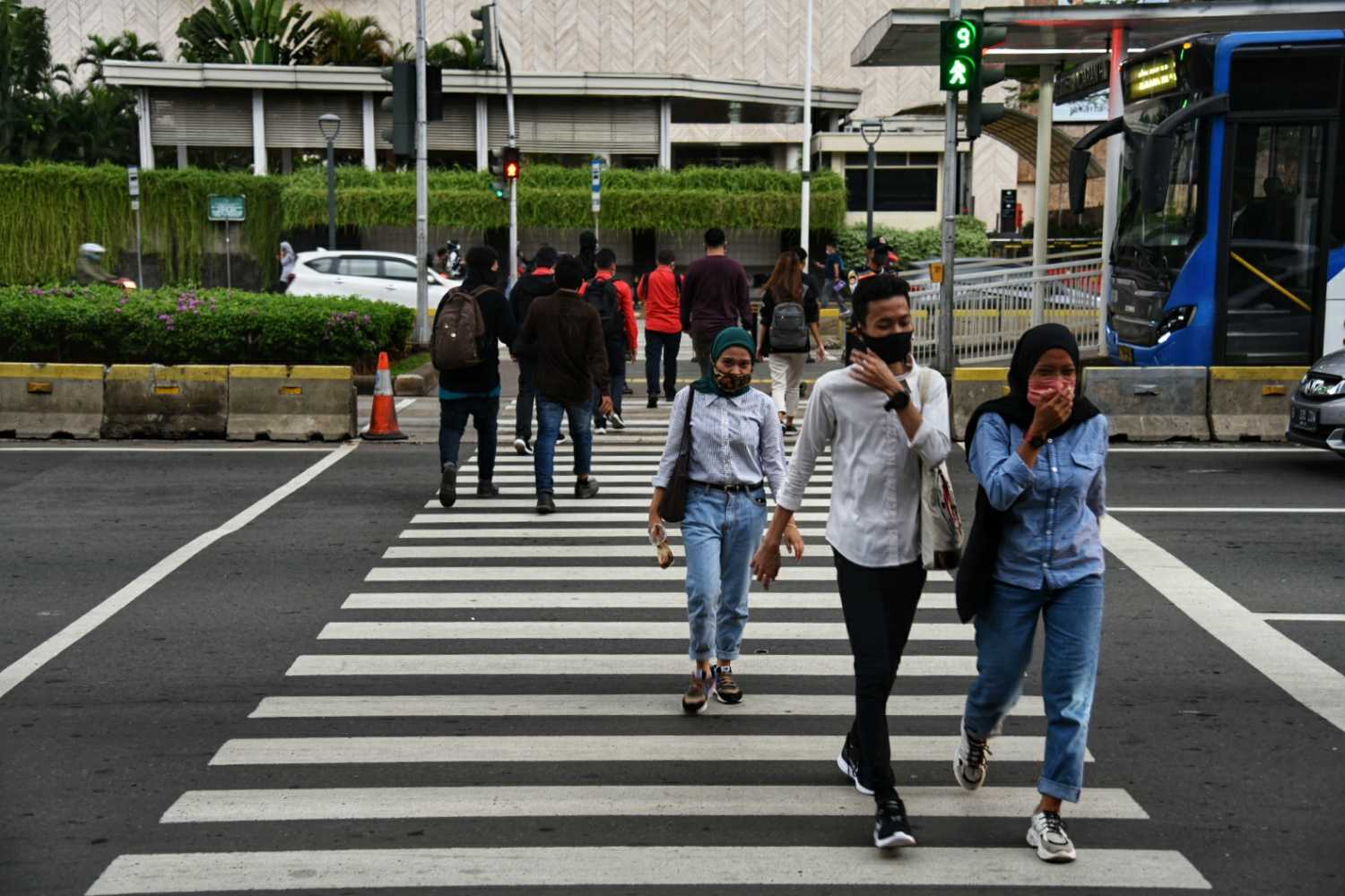 Warga Jakarta mengenakan masker saat beraktivitas di masa PSBB Transisi