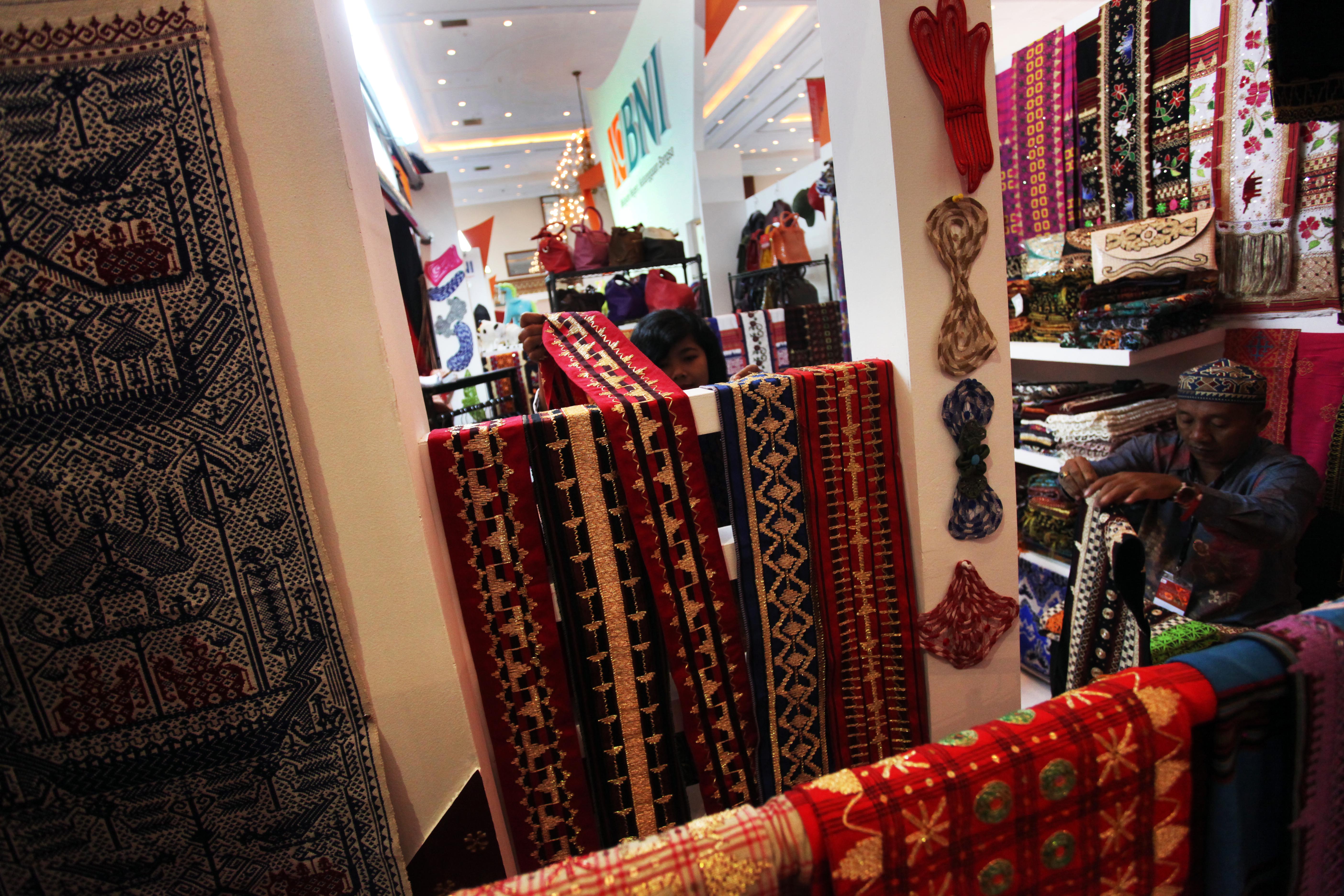  Pengunjung melihat produk kain tenun khas Lampung di stand Kampoeng BNI Tapis Lampoeng pada pameran INACRAFT 2016 di Jakarta  