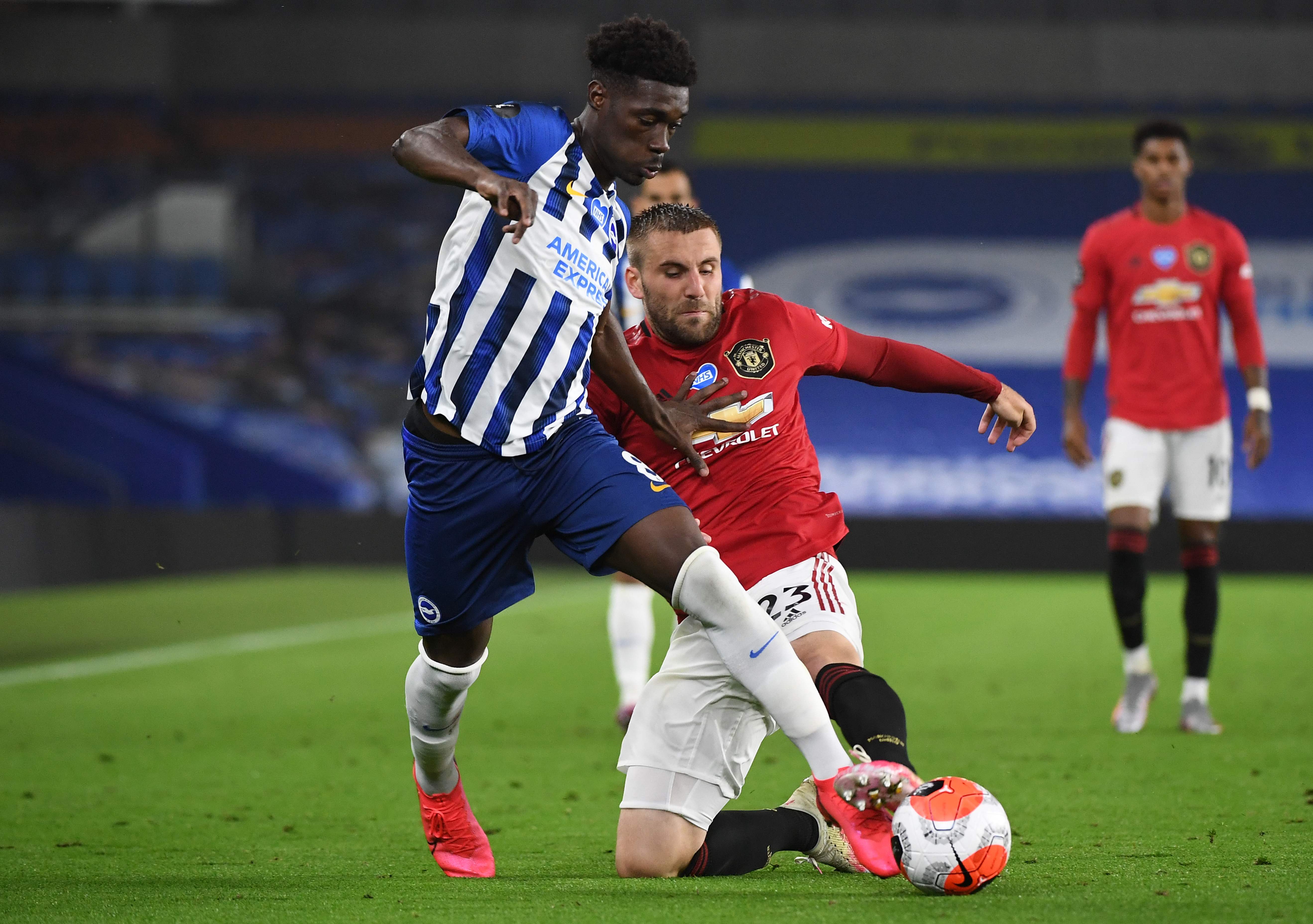 Bek Manchester United, Luke Shaw mencoba merebut bola dari Yves Bissouma, pemain Brighton & Hove Albion (kiri)