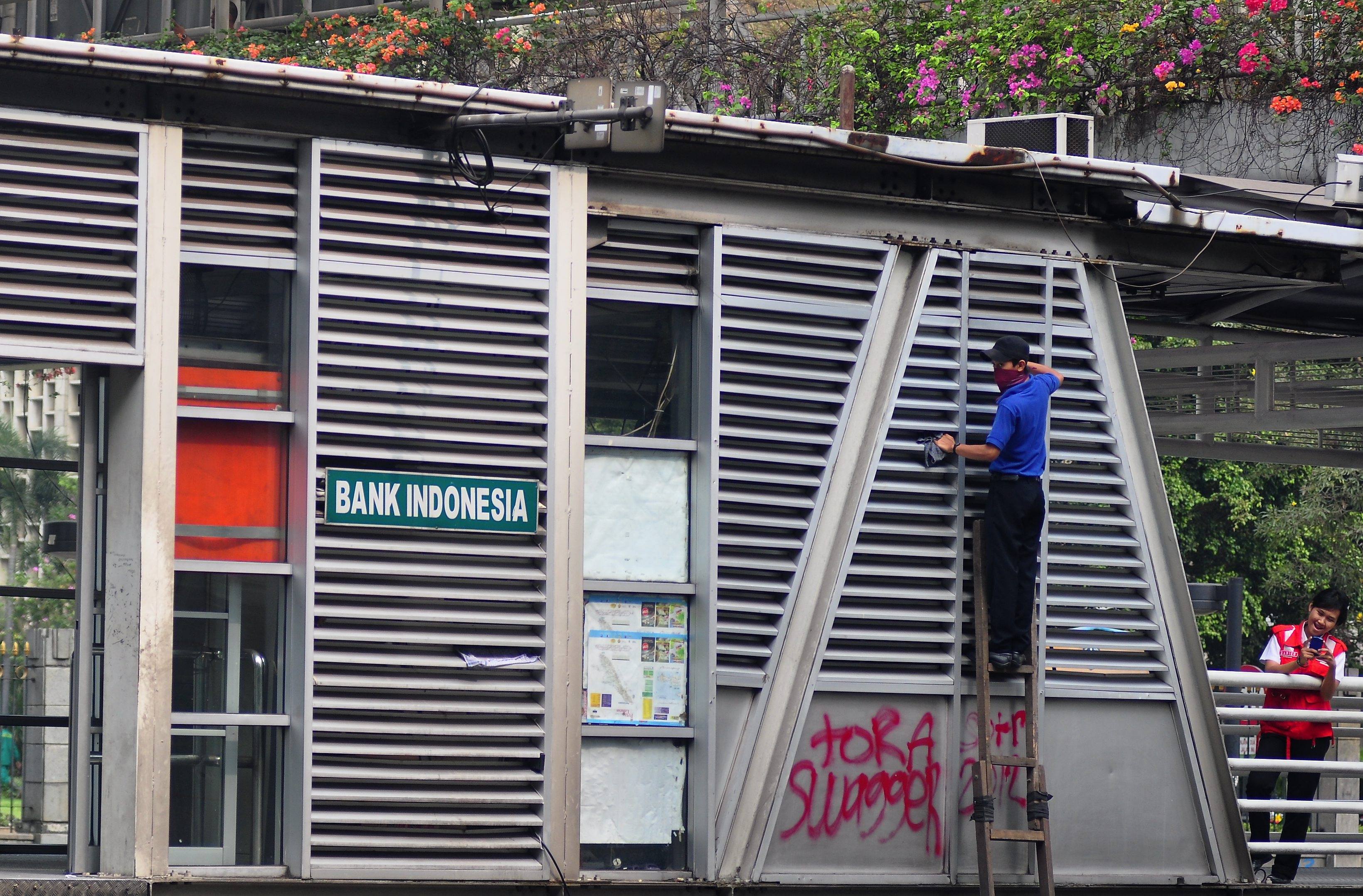 Seorang petugas membersihkan halte TransJakarta Bank Indonesia di Jakarta Pusat.