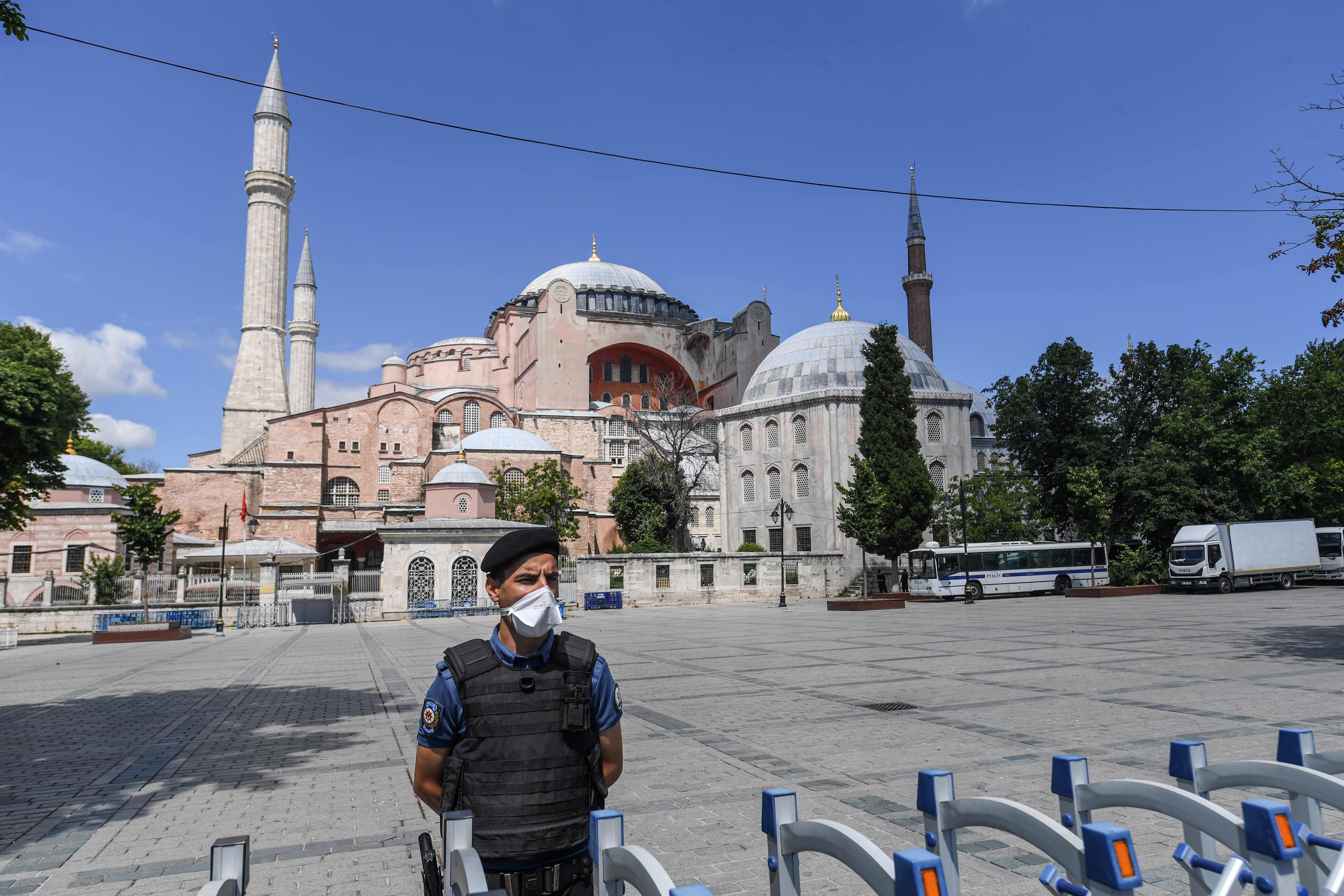 Polisi Turki memakai masker berjaga di halaman masjid Hagia Sophia, Istanbul Sabtu (11/7/2020).   