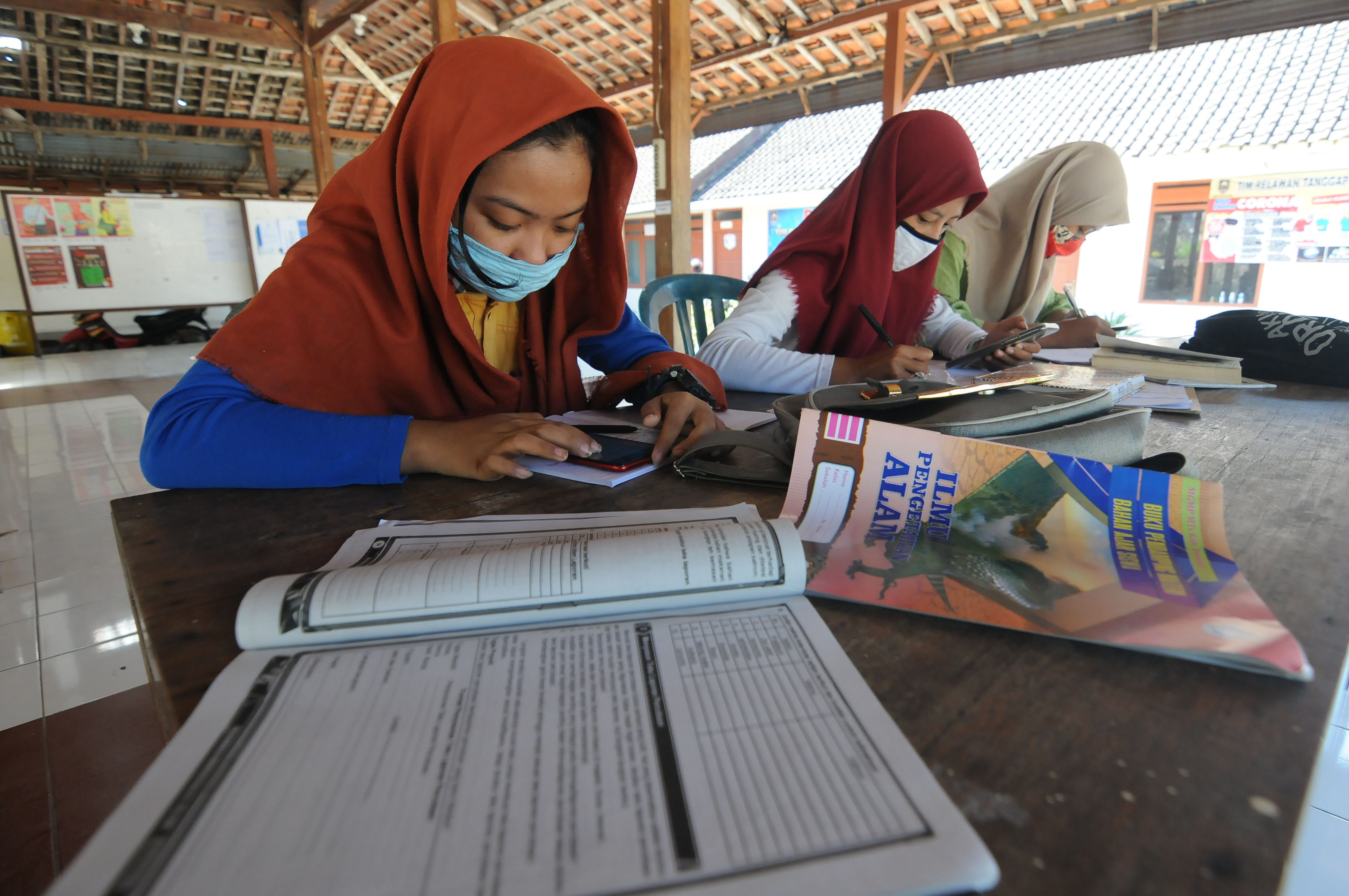  Sejumlah anak mengerjakan tugas pelajaran dari sekolah mereka dengan memanfaatkan fasilitas internet desa di Desa Banyuanyar, Jawa Tengah.