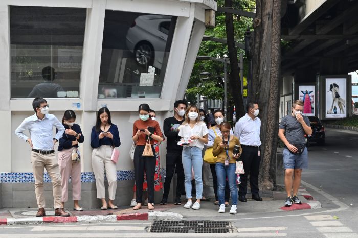 Ilustrasi : Sejumlah warga mengenakan masker saat menunggu menyeberang jalan di Kota Bangkok.  