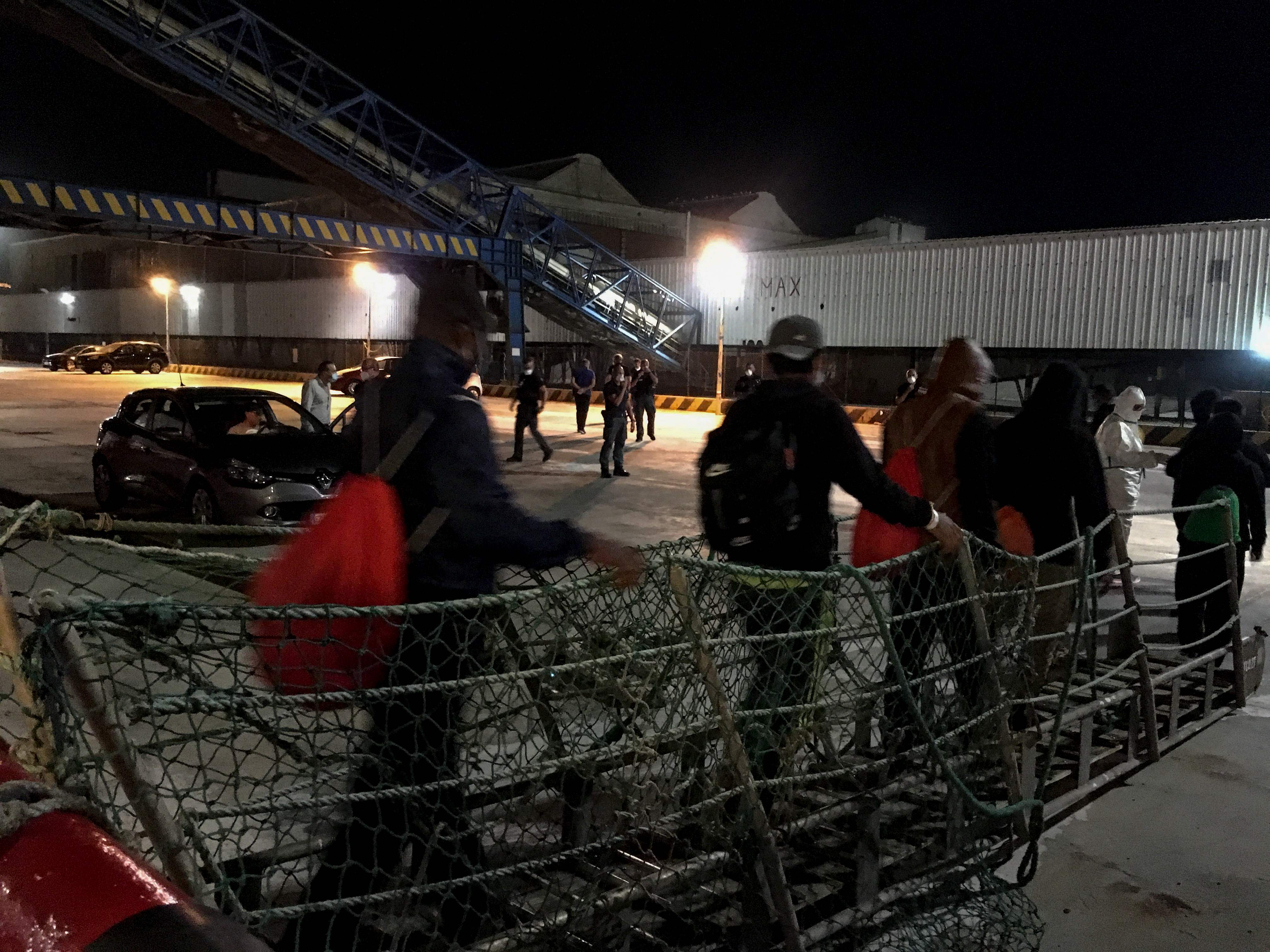 Para imigran turun dari kapal Viking Ocean di Porto Empedocle, Sisilia, Italia.