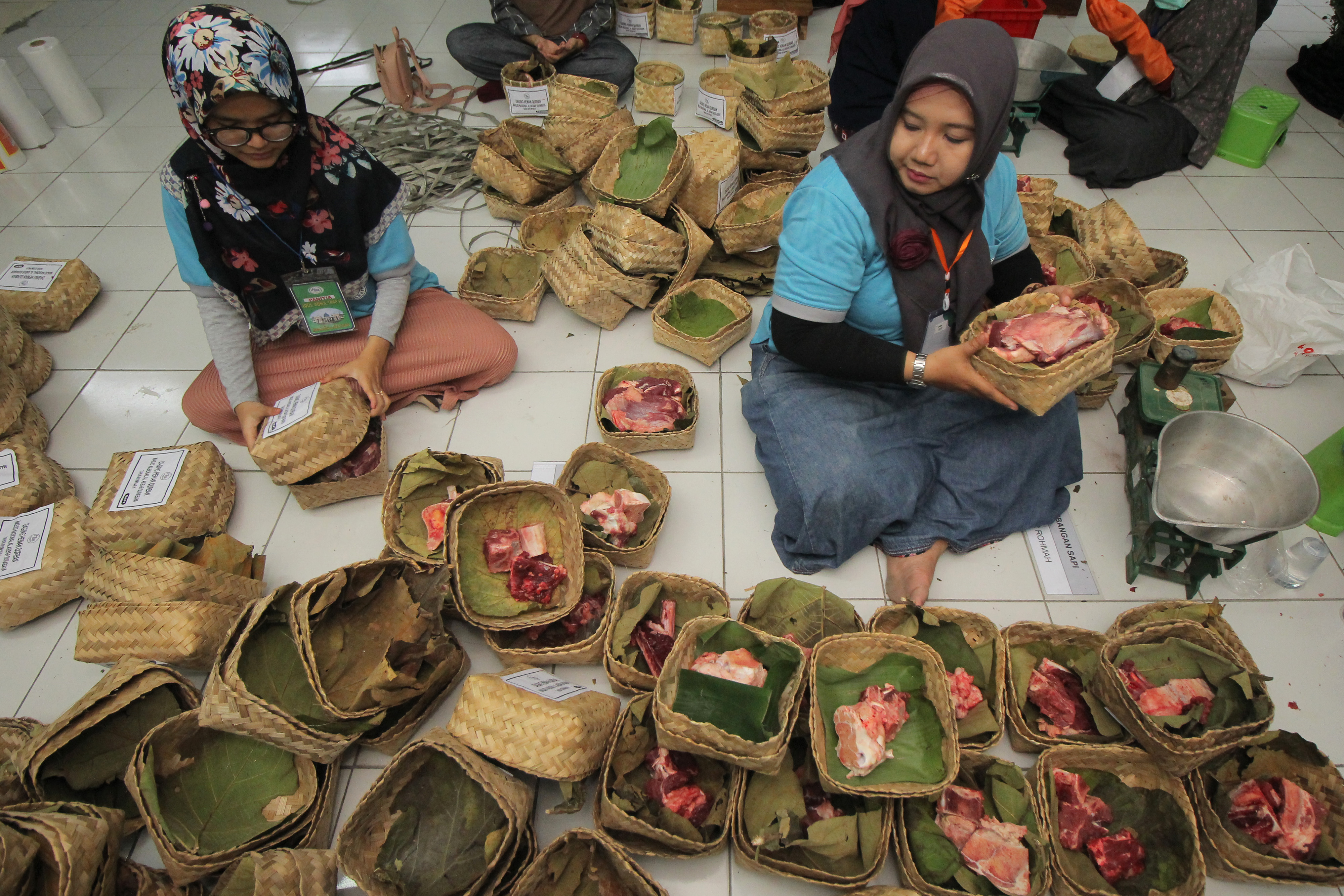 Pengemasan daging kurban dengan menggunakan besek, di Masjid Al Akbar, Surabaya, Jawa Timur, Senin (12/8/2019)