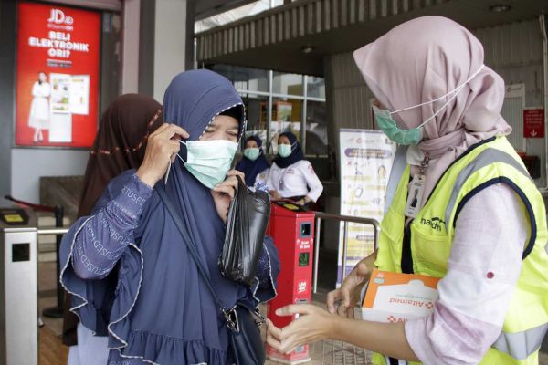 Pembagian masker gratis kepada warga di Stasiun Depok Baru, Depok, Jawa Barat, Selasa (3/3/2020).   